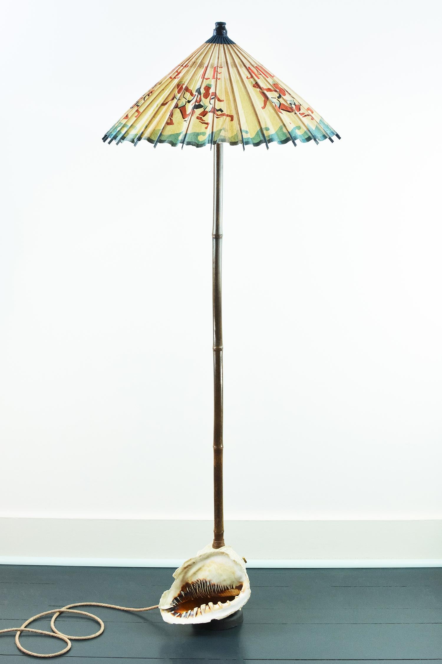 Model No. 014 is a one-of-a-kind art lamp featuring a vintage rice-paper shade constructed from an exceedingly rare 1919 French parasol advertising a line of cold-water bathing suits.

The shade sits atop a lacquered, mahogany brown black bamboo
