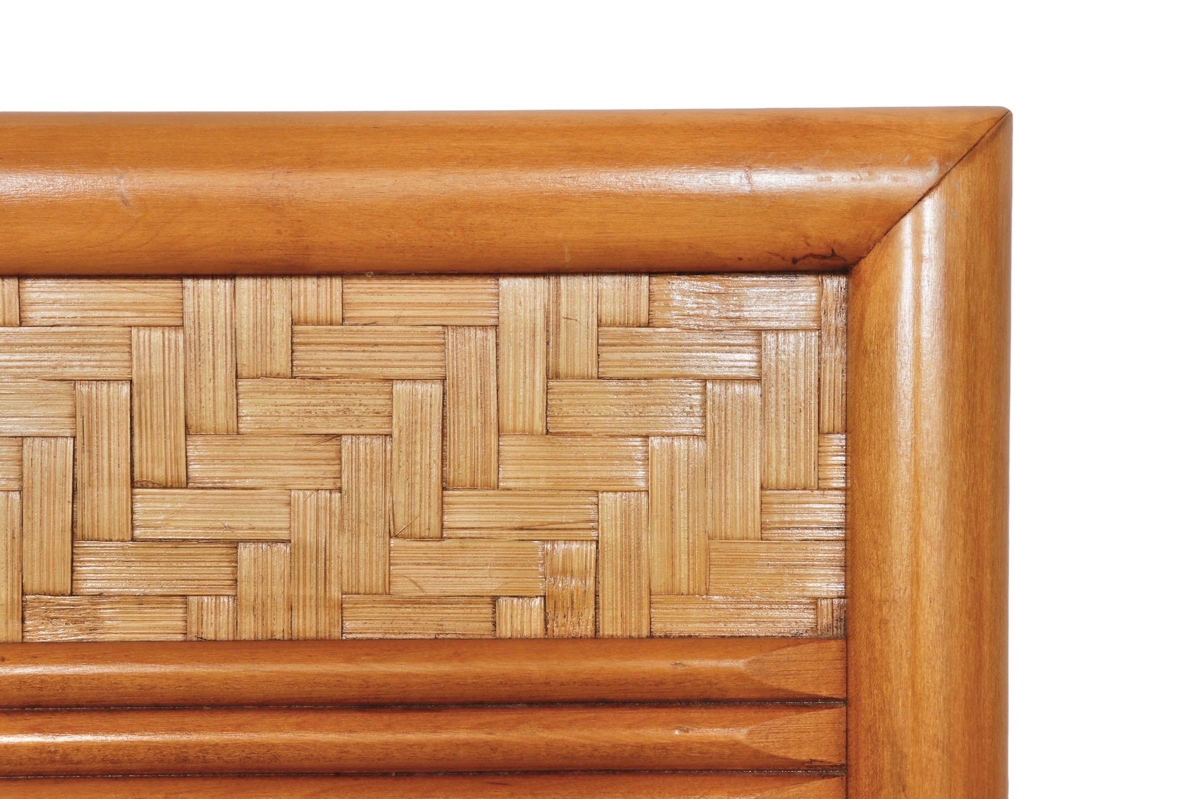 A queen size headboard made by Dixie furniture company. A maple frame is decorated with a panel of rattan woven in a herringbone pattern. Marked ‘Dixie made in the USA’ in the back.