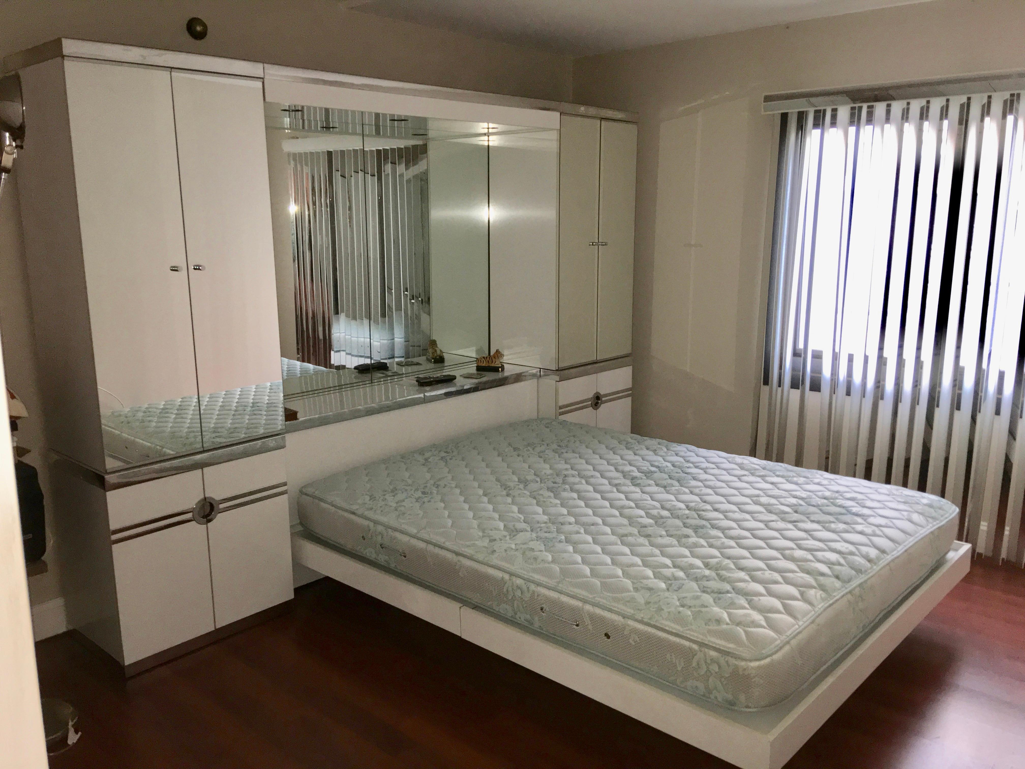 Pierre Cardin queen size platform bed with double wardrobe units, spotlight bridge and headboard cabinet. Presented in white gloss laminate embellished with chrome banding and mirror.

Elements included are the queen size platform bed itself;