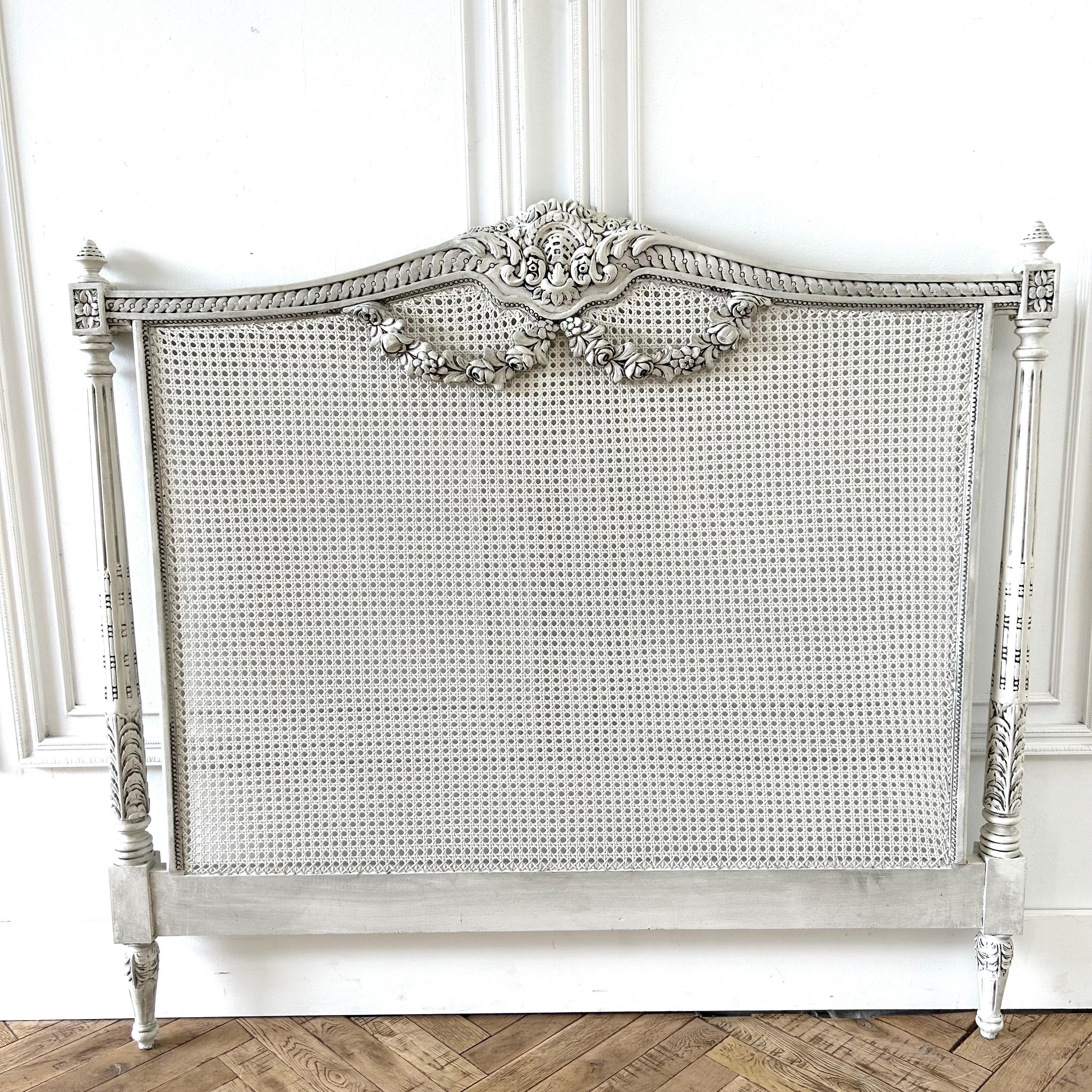 Painted French Country Queen headboard with cane and rose swag carvings.
Painted in a soft off-white oyster color, with subtle distressed edges, antique glazed patina.

Size: 61” W x 3” D x 57” H.