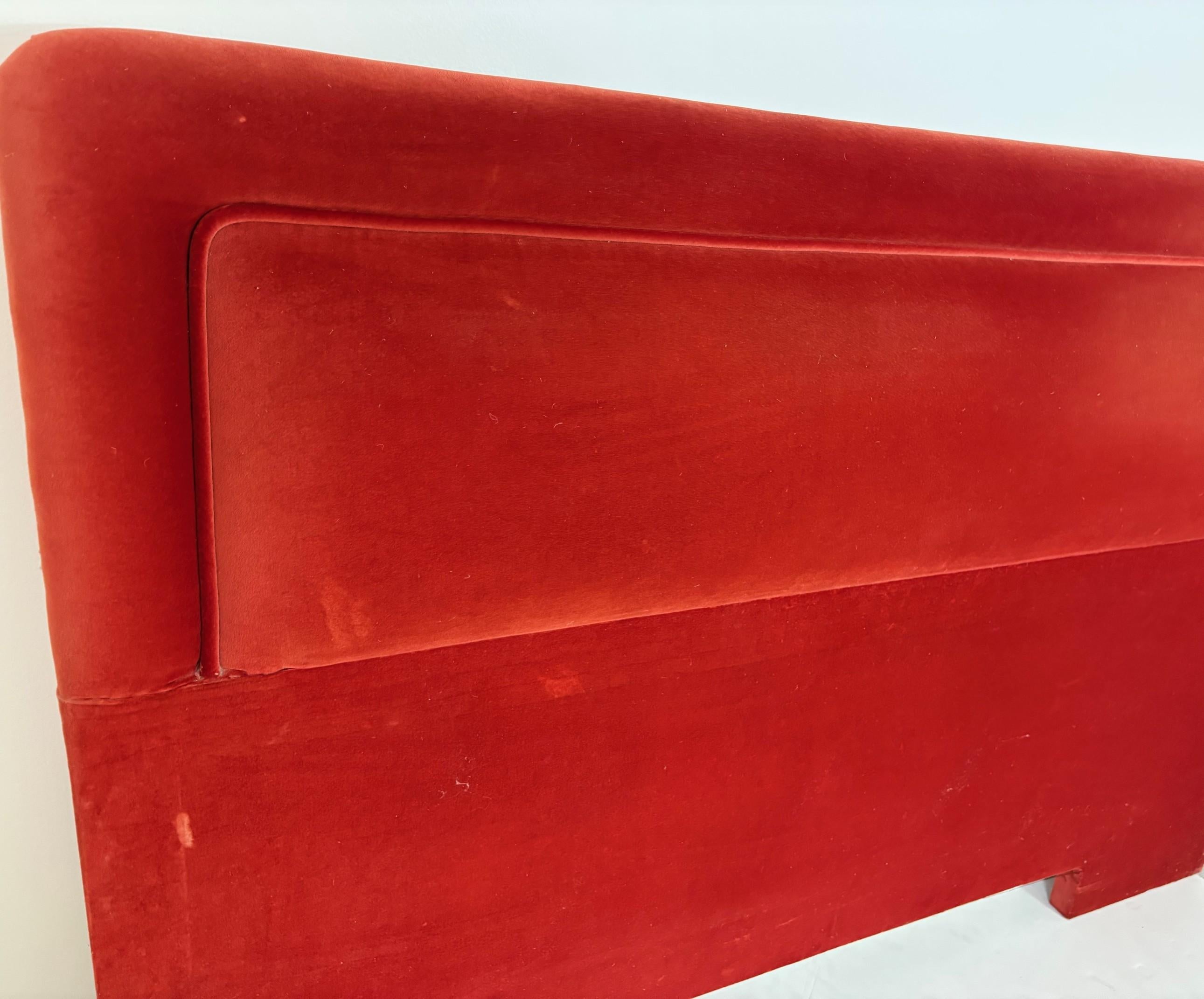 A queen-size headboard covered in velvet fabric.
