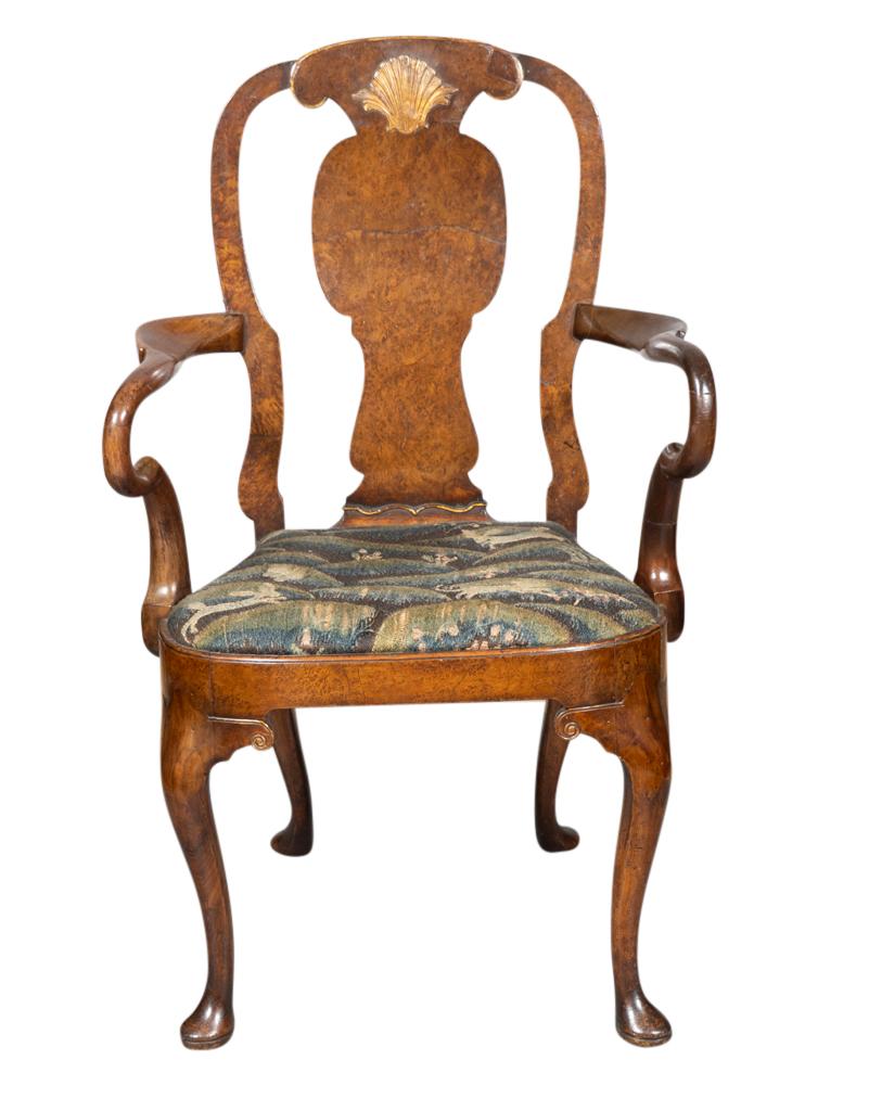 With an arched back with gilded shell over a shaped splat. Scrolled arms and drop in crewel upholstered seat. Cabriole legs and pad feet.