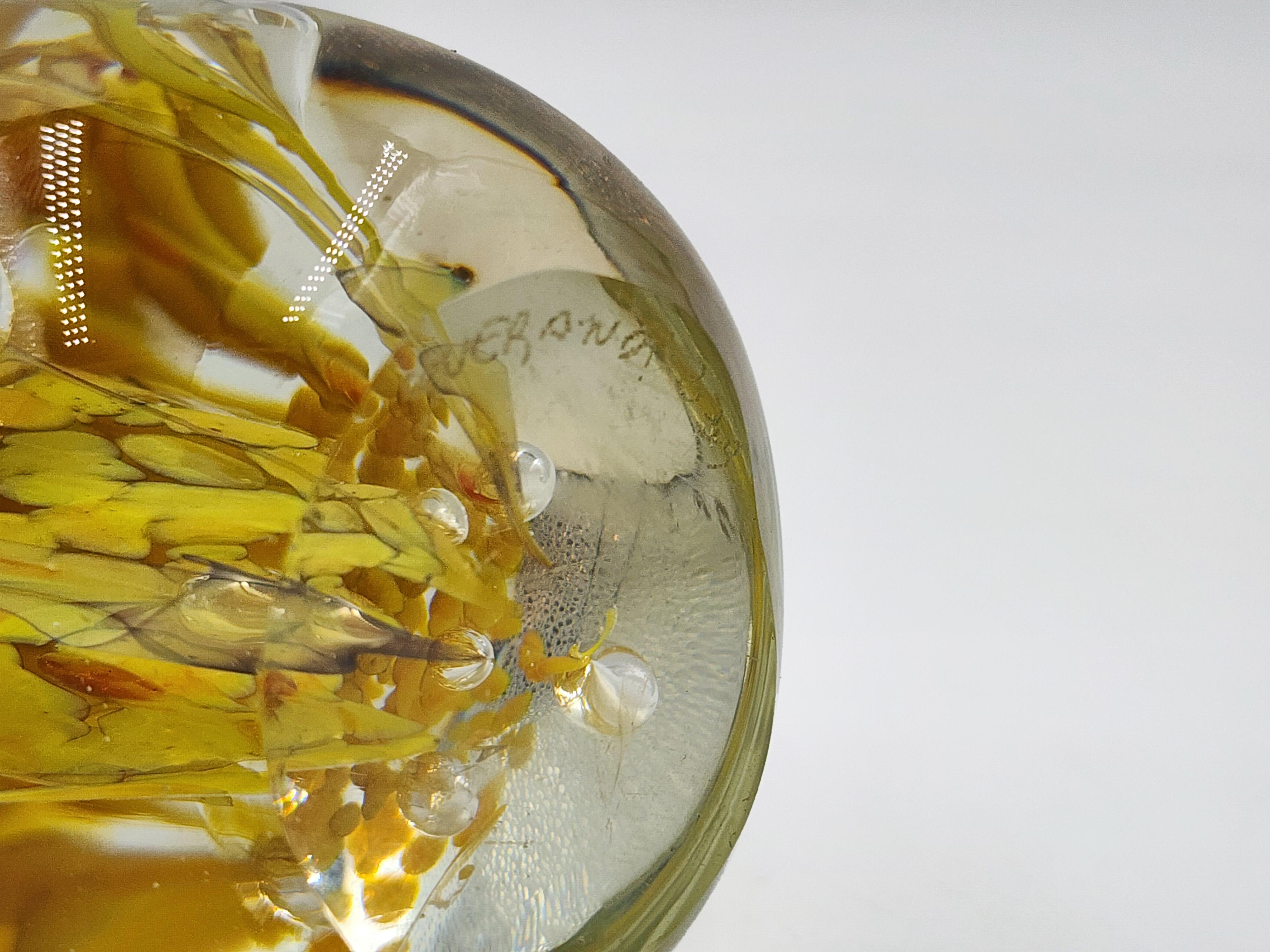 Querandi Glas Briefbeschwerer
Dieser Briefbeschwerer aus Glas von Querandi aus den 1970er Jahren hat eine ovale Form, die an ein Ei erinnert, und einen flachen Sockel, der für Stabilität sorgt. Das Innendesign besteht aus einer Komposition in