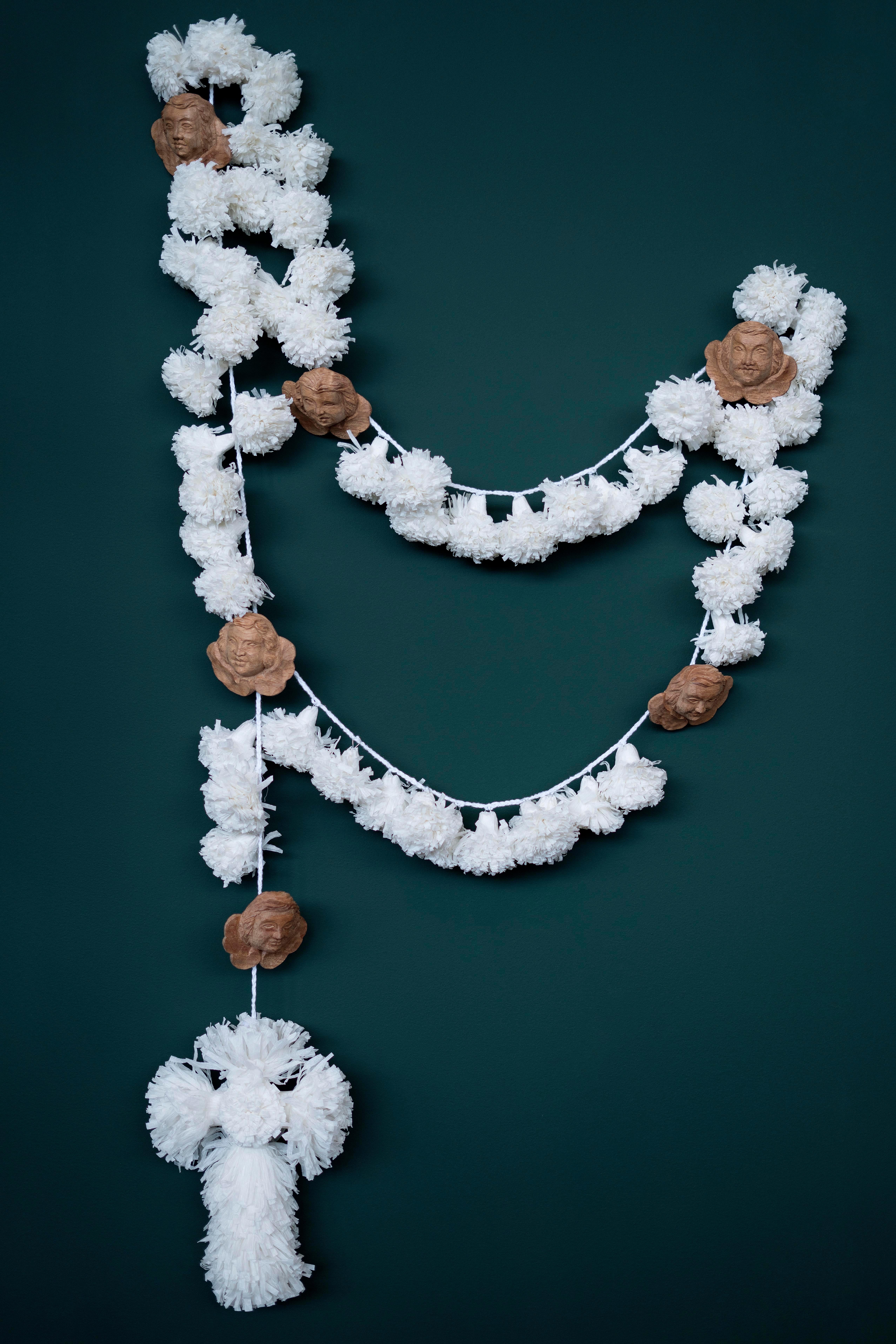This Rosary is made with crepom paper pompons and cross, a work of D. Lilia Fonseca, and hand wood carving querubins, made by Rondinelly Santos, D. Lilia's nephew, and a sacred art sculptor. All this pieces are put together by D. Maria Conceição de