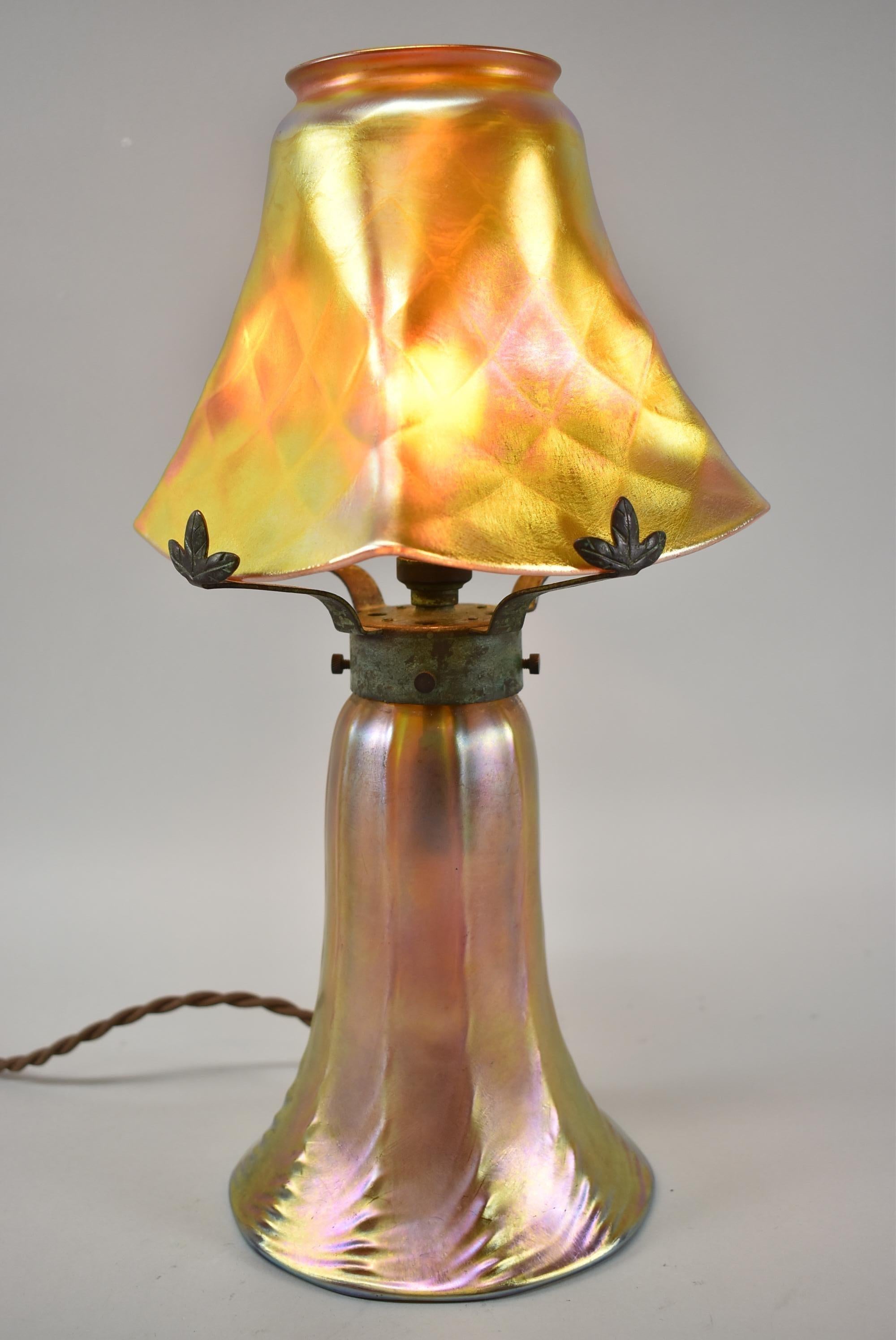 Quezal art glass table lamp with single socket. Signed on the fitter. Brass mounts with a green bronze patina. Rewired.