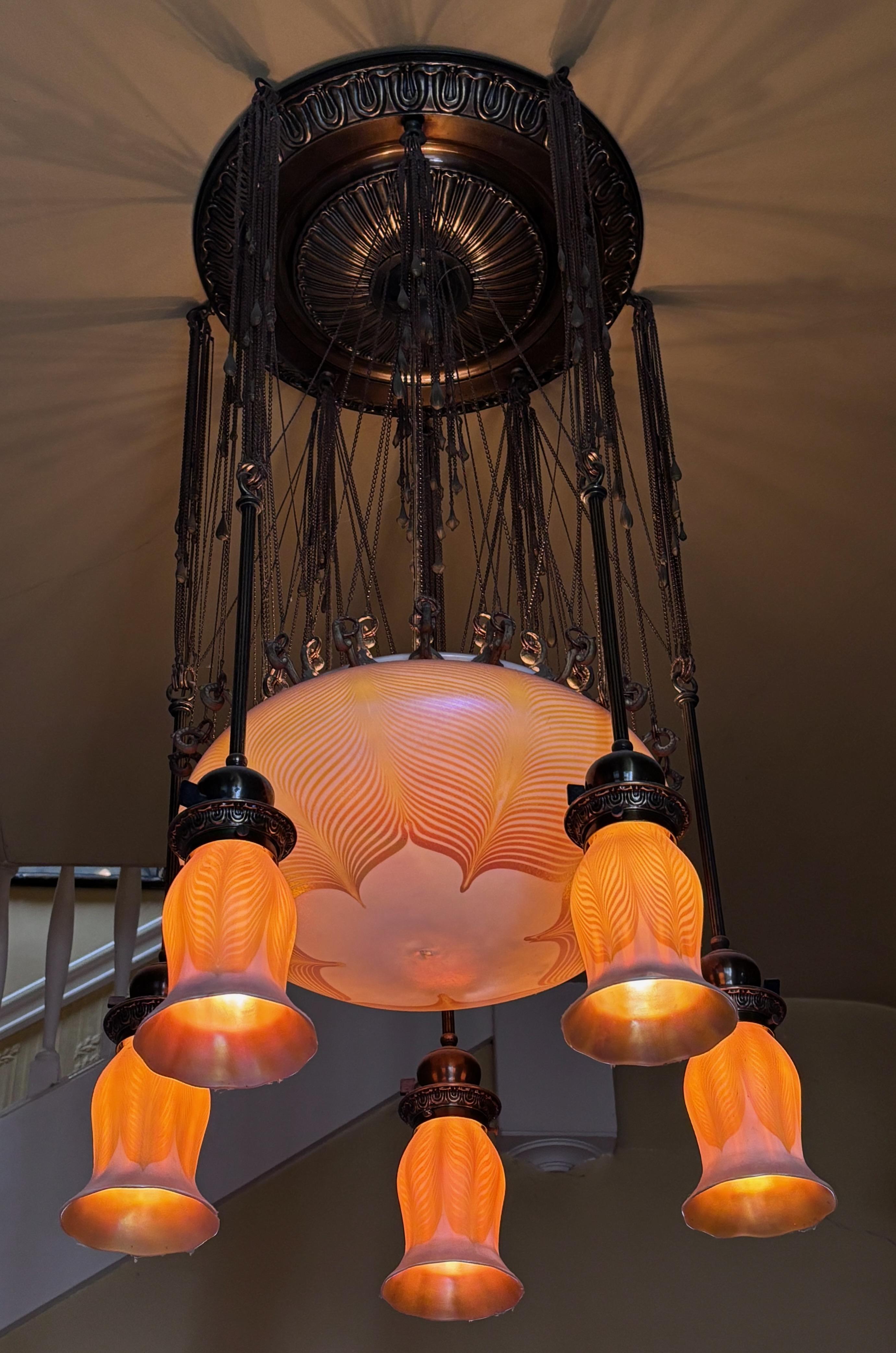 An extraordinary Art Nouveau period Quezal art glass chandelier in wonderful and remarkable original condition. Purchased from an estate in San Francisco where it was originally installed in the early 20th century. The art glass bowl and shades are