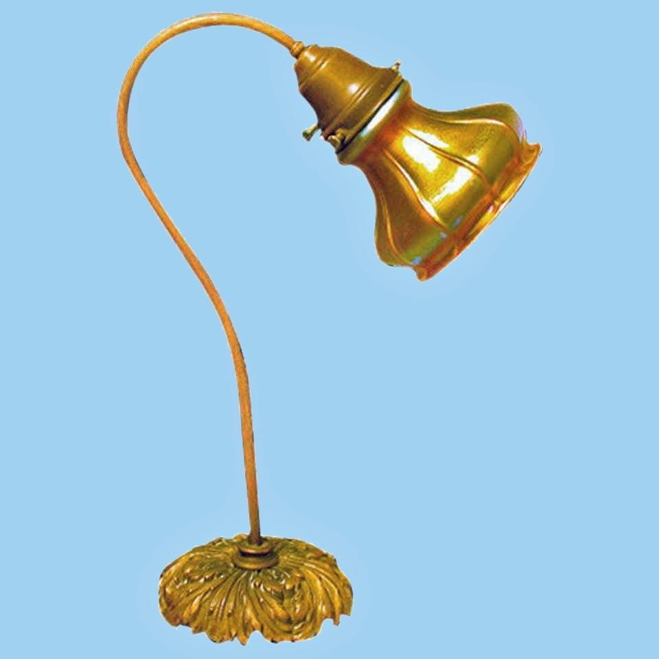 Fine Quezal glass desk lamp, circa 1910. The gooseneck patinated metal and dome shape acanthus brass base, fitted with a signed Quezal shade. The shade of swirl panel bulbous form, the gold exterior with tones of violet, green and blue iridescence.