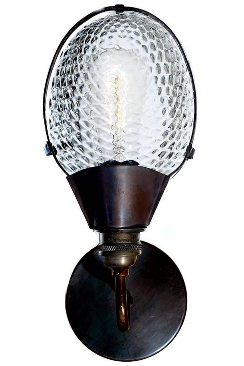 Quelle belle lampe, simple et élégante. Les abat-jours en verre transparent ont un motif matelassé unique et s'enclenchent dans le cadre en cuivre de la lampe. Le verre et le cadre sont inspirés des réflecteurs de vitrines de magasins du début du