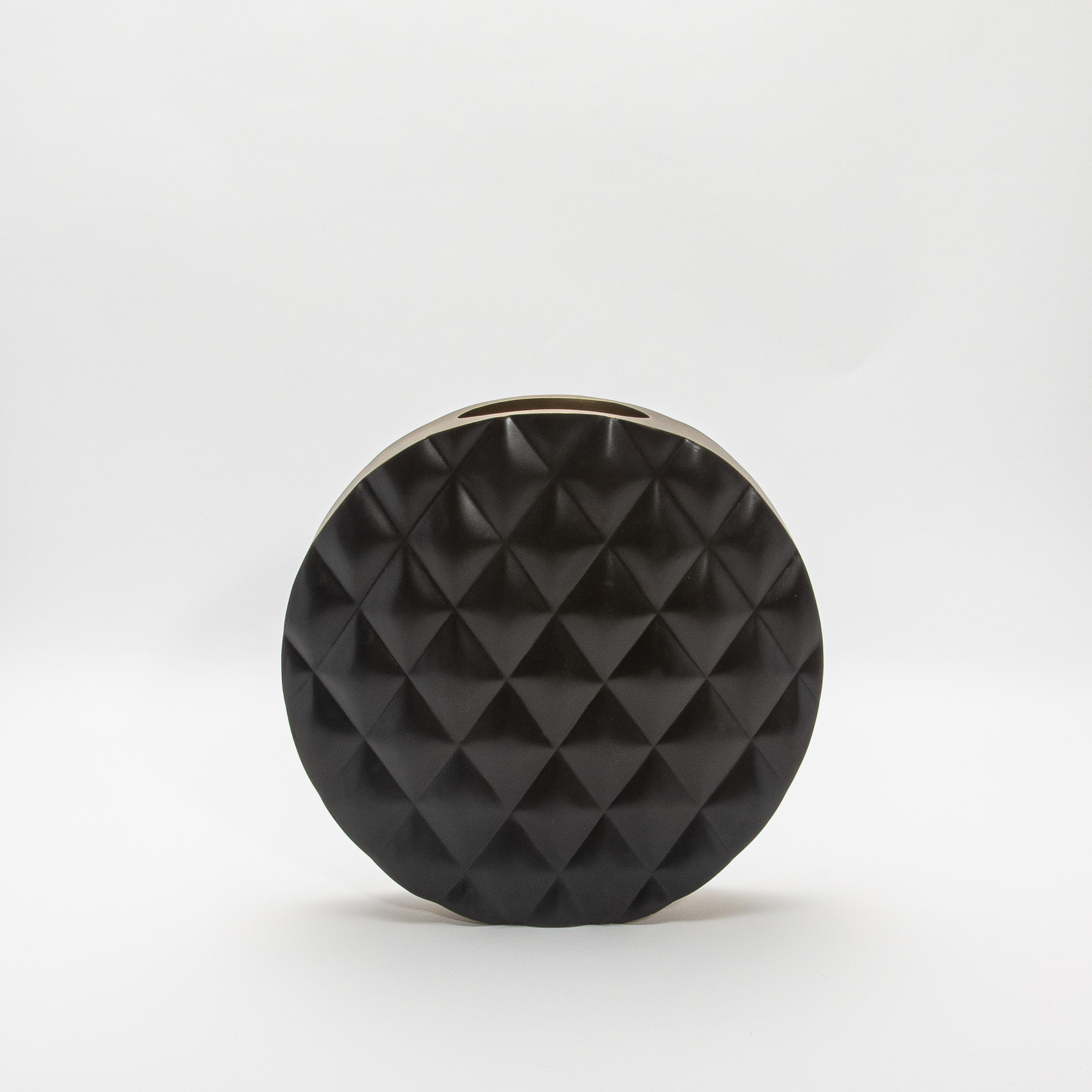 Die Vase Coco von KIFU Paris ist eine faszinierende Verschmelzung von geometrischer Kunstfertigkeit und exquisiter Handwerkskunst. Die Vase aus luxuriöser schwarzer Eiche hat eine auffällige, gesteppte Struktur, die ihrer runden Form einen