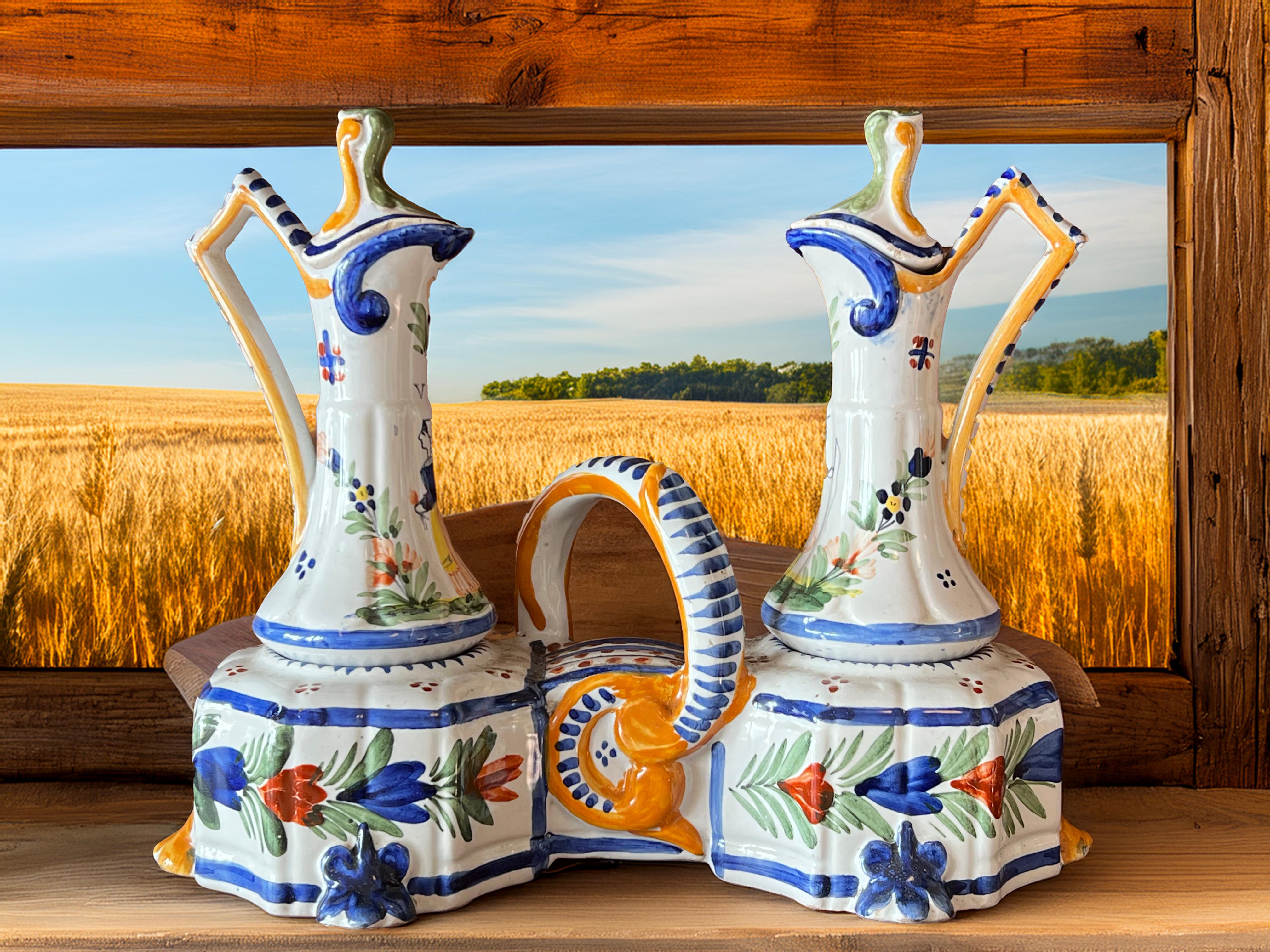 Late 19th century to early 20th century Quimper earthenware oil and vinegar set, signed HB Quimper manufacture located in Brittany, France. 
It consists of a stand, two small carafes with two lids, all made of earthenware with handmade decoration.