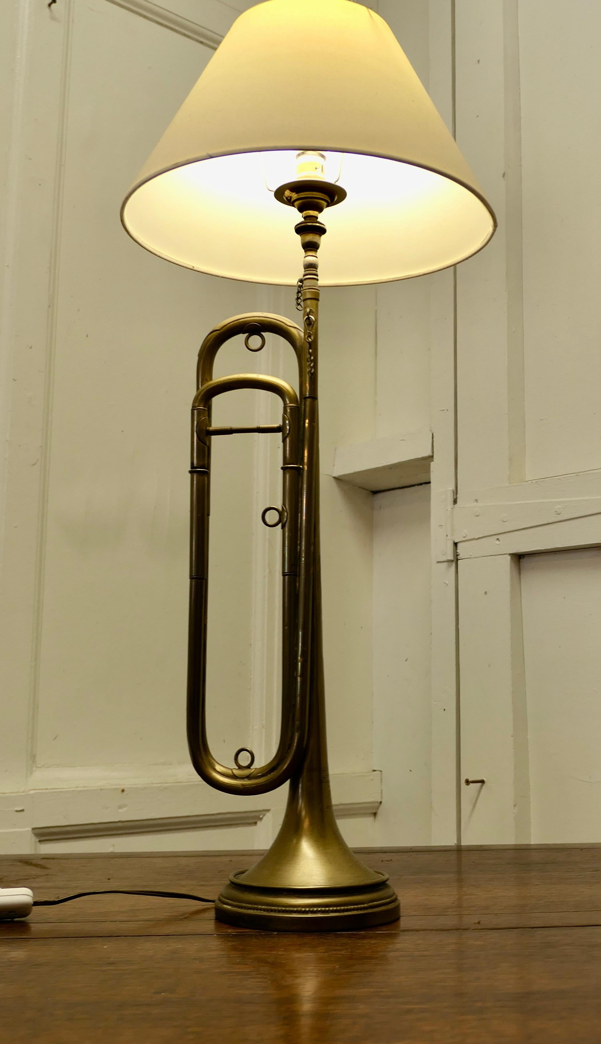 Quirky Brass table lamp made from a Trumpet

This would be great in a Musical or Jazz Club design setting
The Lamp is well balanced, it has been wired for electricity and has a parchment shade
The Lamp is 28” high, 12” in diameter (shade) 8”