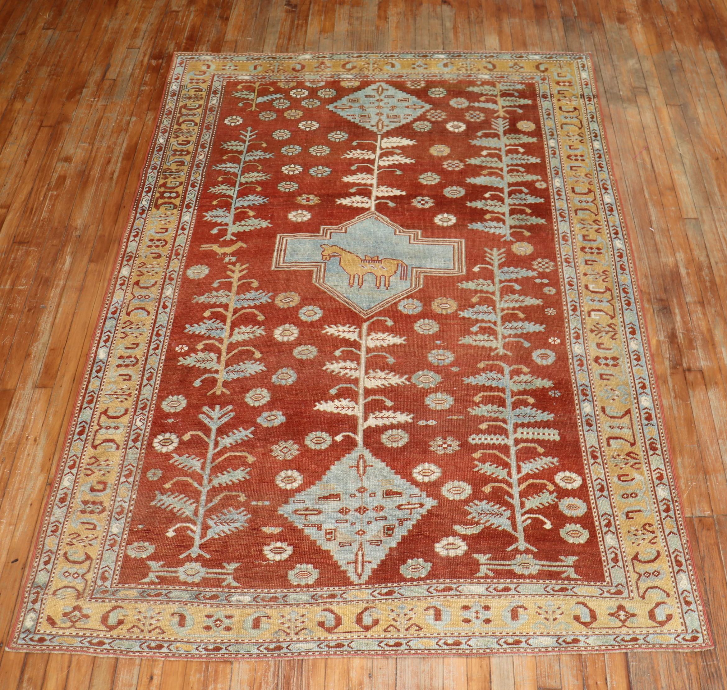 A geometric tribal looking Caucasian rug from the second quarter of the 20th century with saffron ground, accents in light blue and a goldenrod border. The central medallion has a camel on it, circa 1930.

Measures: 5'9
