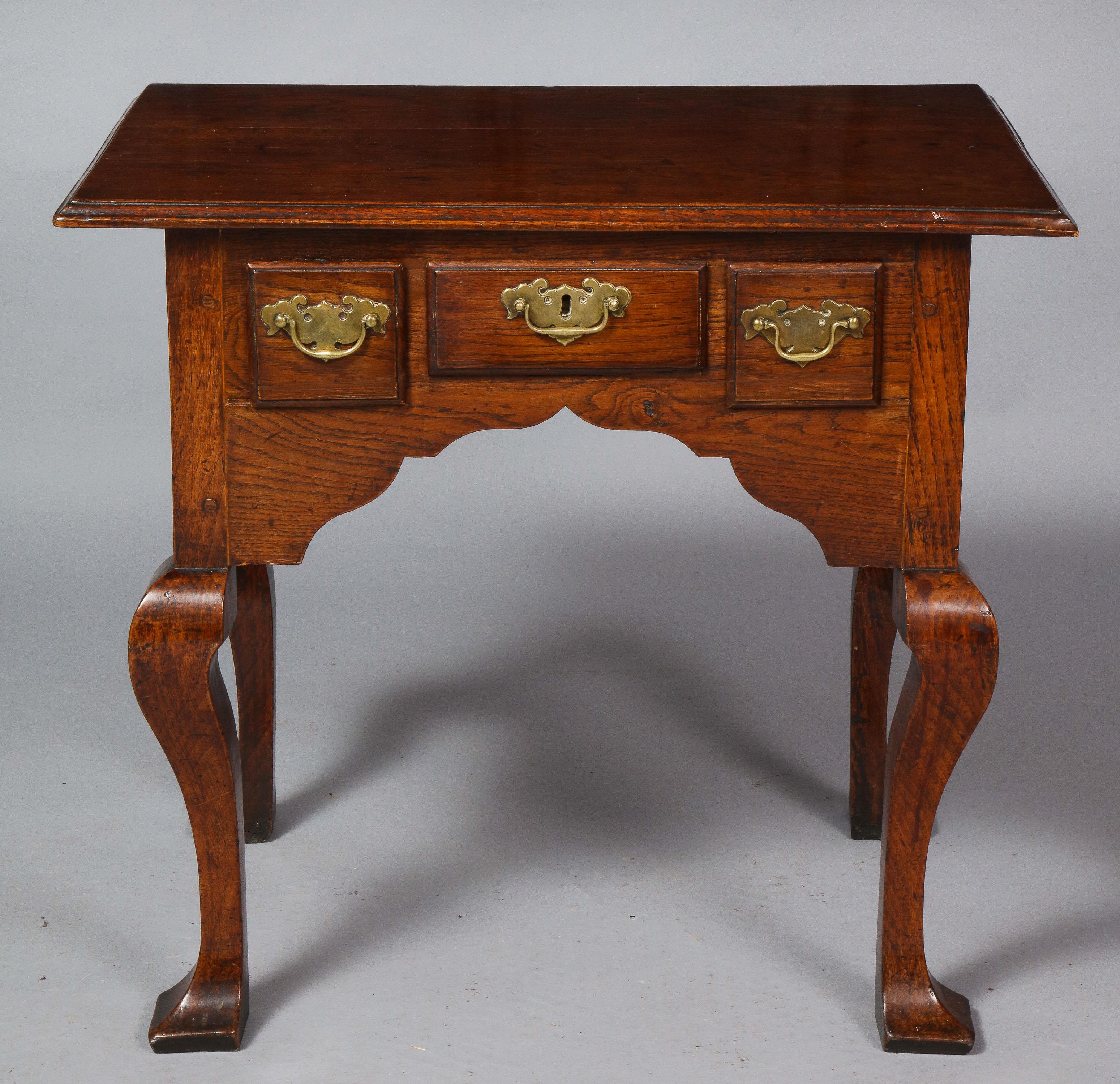 Very fine 18th century Welsh oak lowboy, the top with molded edge over two short and one wide drawers, all retaining original overscale hardware over richly scalloped apron and standing on square cut cabriole legs, the sides also with generous