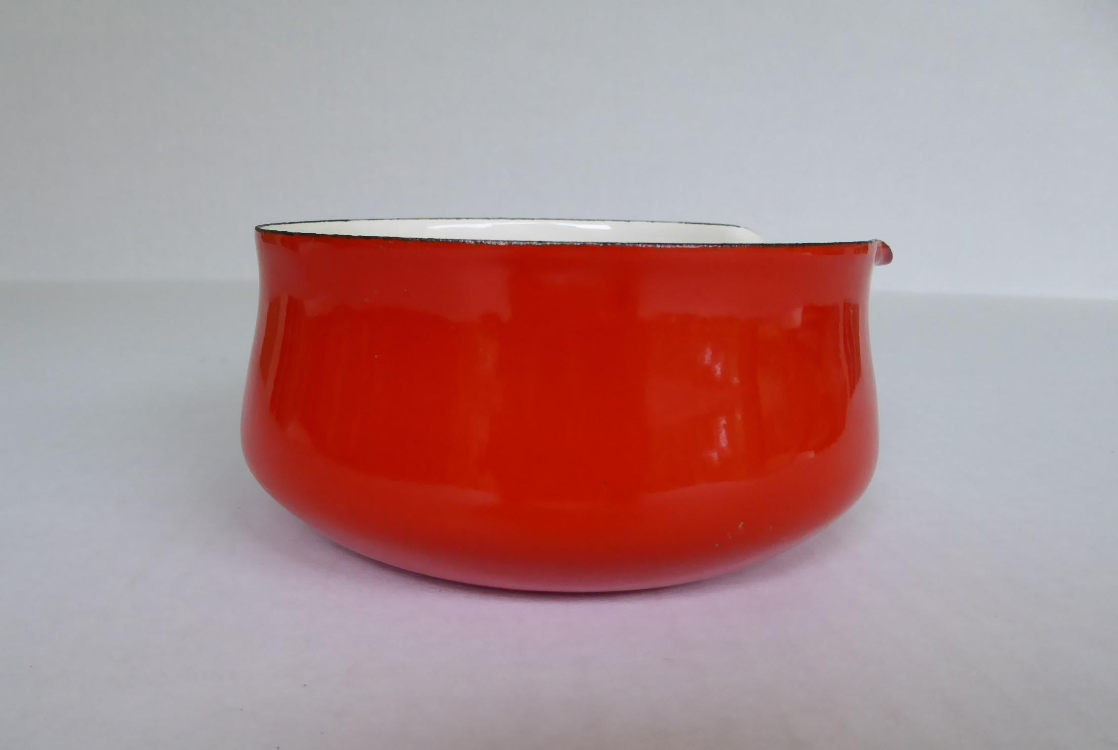 Early Dansk Designs bright red enameled iron Koben style petite saucepan with woven plastic wrapped handle from the mid-1950s. In very good condition, minor wear consistent with age, small flakes on one side (view pics). Stamped on the bottom with