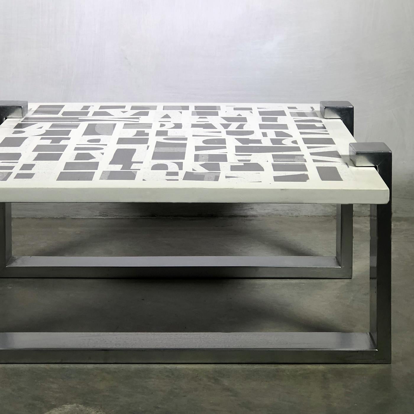 This stunning coffee table will be a superb addition to an industrial or contemporary living room. Its top is adorned with a series of abstract motifs in brass and concrete that evoke the symbolic power of letters and numbers. The two bracket-like