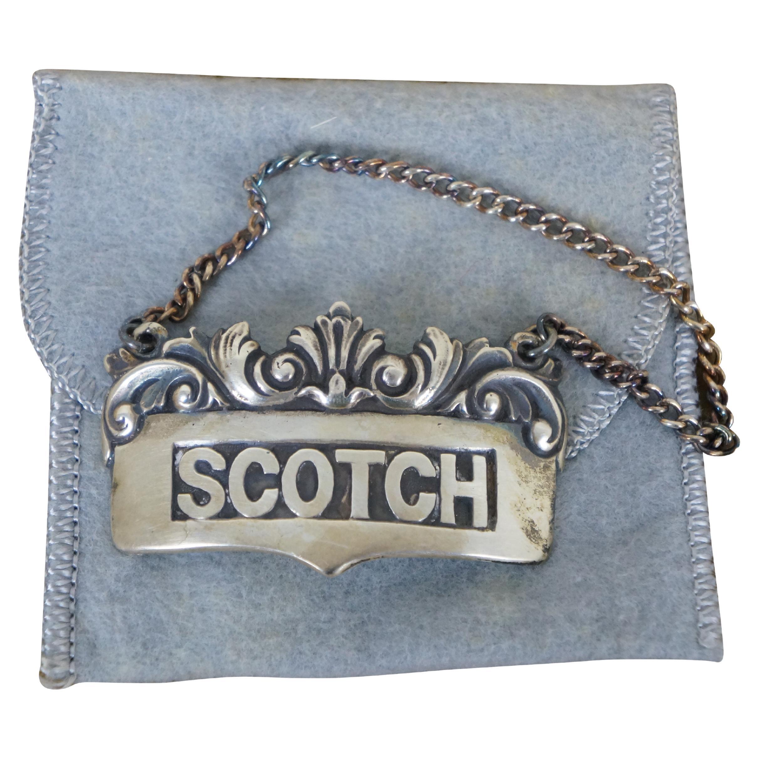 Decanter per scotch in argento sterling barocco della metà del XX secolo / etichetta per bottiglia / ciondolo su catena di R. Blackinton & Company.

R. BLACKINTON & CO - North Attleboro, MA - 1862-1967

Dimensioni:
2,25