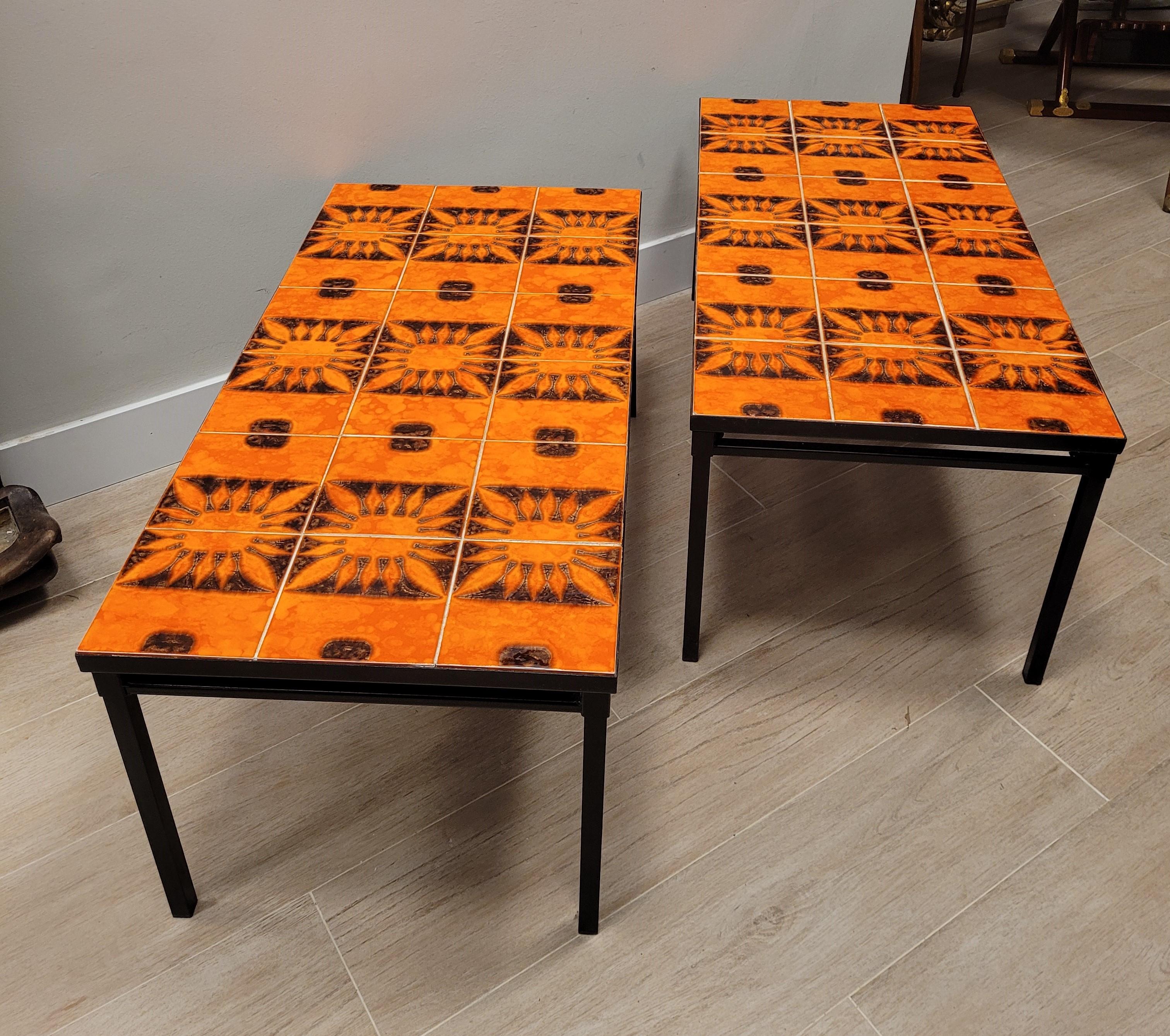 
 
Remarquable paire de tables basses de forme rectangulaire conçues selon l'esprit et le travail de Roger Capron au milieu du siècle dernier dont le plateau est constitué de pièces de céramique de Vallauris avec des motifs solaires dans une