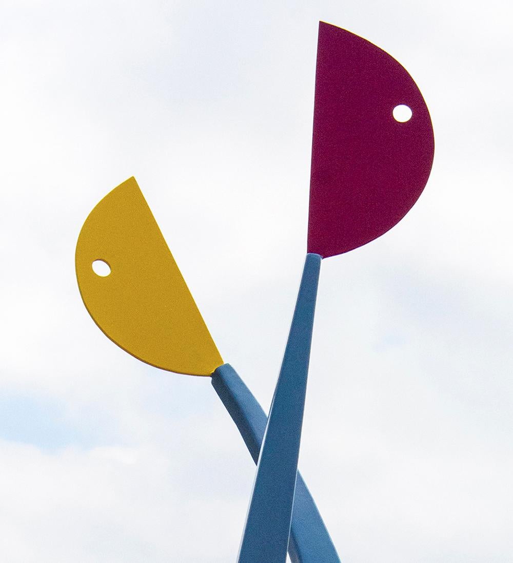 Two abstracted figures in painted steel intersect in this playful outdoor sculpture by R. Clarke Ellis. The work integrates minimalist forms with a theatrical theme expressed through color and spatial tension.  

Ellis holds a MFA from Cranbrook