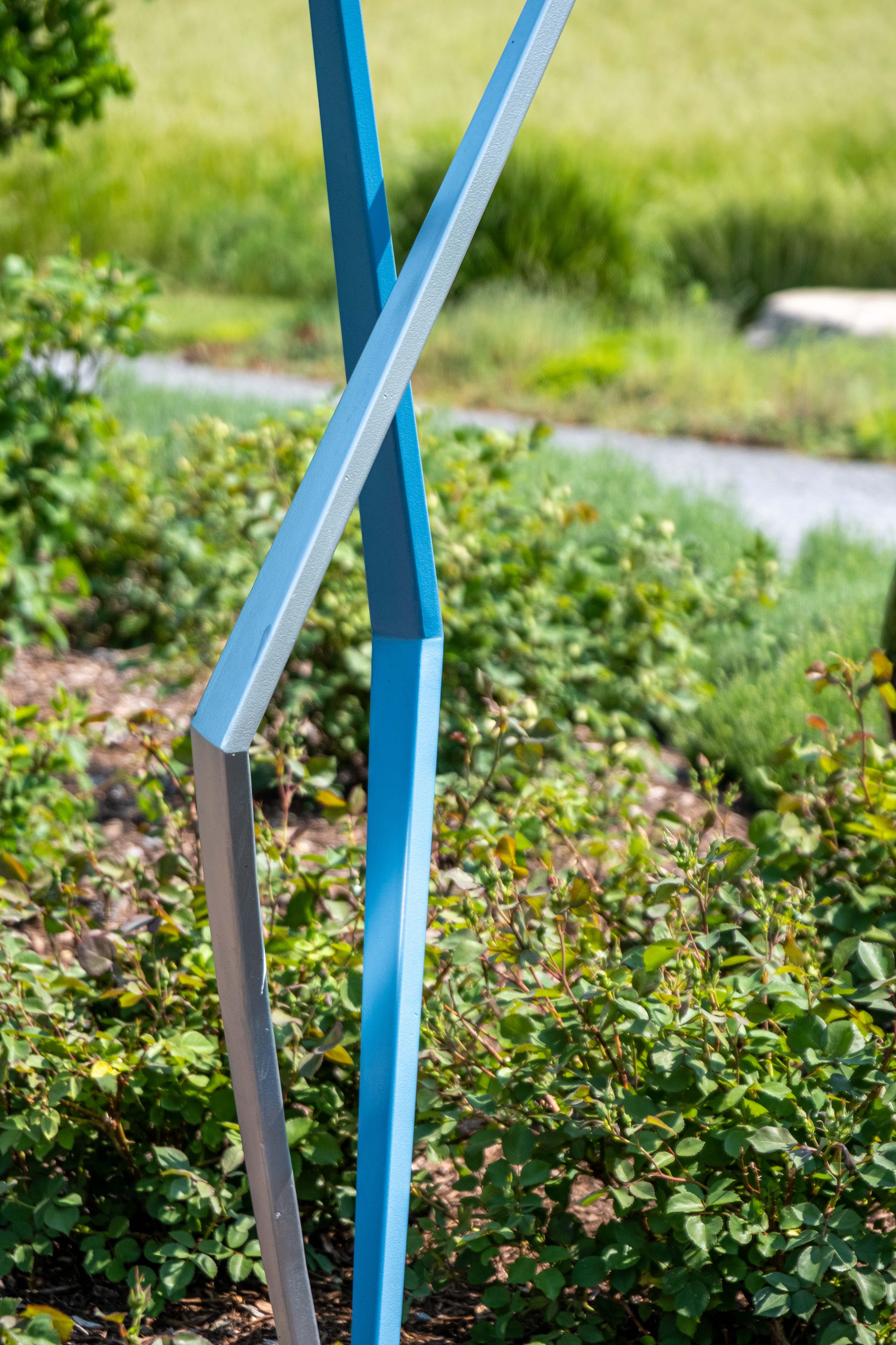 Kräftige, klare Linien und lebhafte Farben ziehen den Blick des Betrachters auf diese minimalistische Skulptur von Robert Clarke-Ellis. Der Künstler aus Toronto schafft ausdrucksstarke, aus Stahl geschmiedete Werke. Die stäbchenförmigen Figuren in