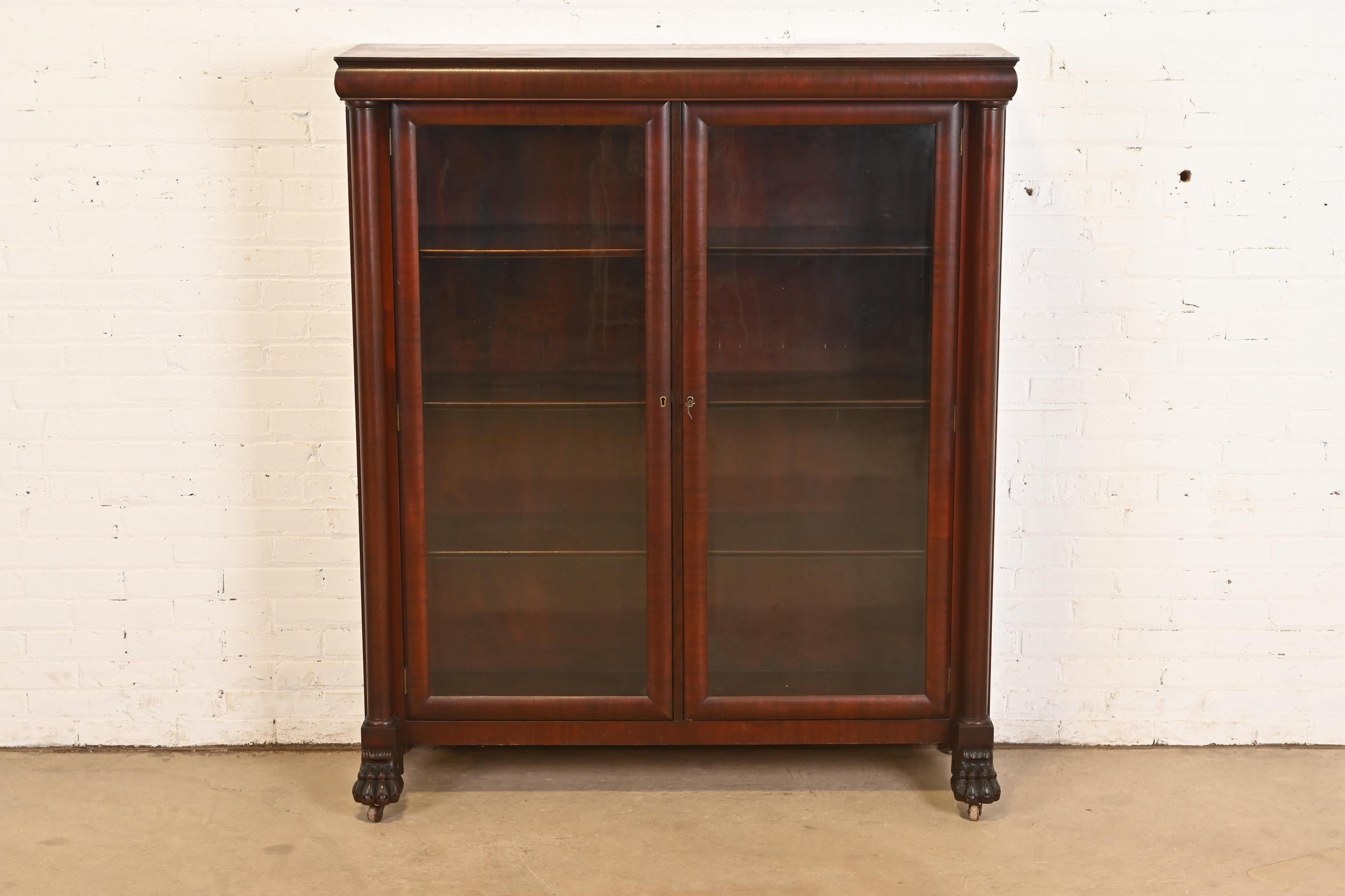An outstanding antique American Empire or Victorian bookcase cabinet

In the manner of R.J. Horner & Co.

USA, Circa 1890s

Mahogany, with carved columns and lion paw feet, and glass front doors. 

Measures: 52.63