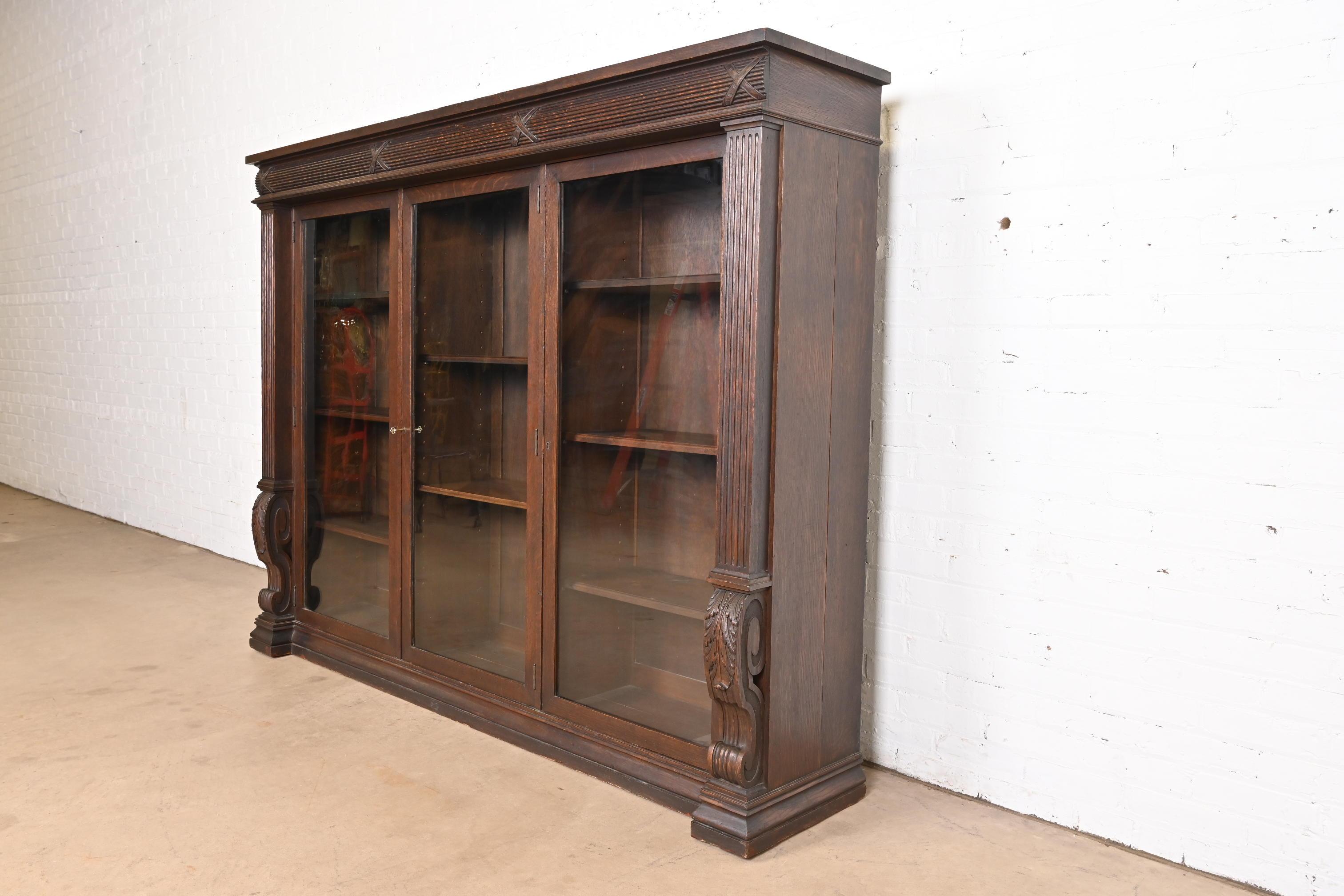 Magnifique bibliothèque triple de style Empire américain ou de la fin de l'époque victorienne

À la manière de J.R. Horner

USA, Circa 1900

Magnifique chêne sculpté, avec des portes d'entrée en verre. L'armoire se verrouille et la clé est