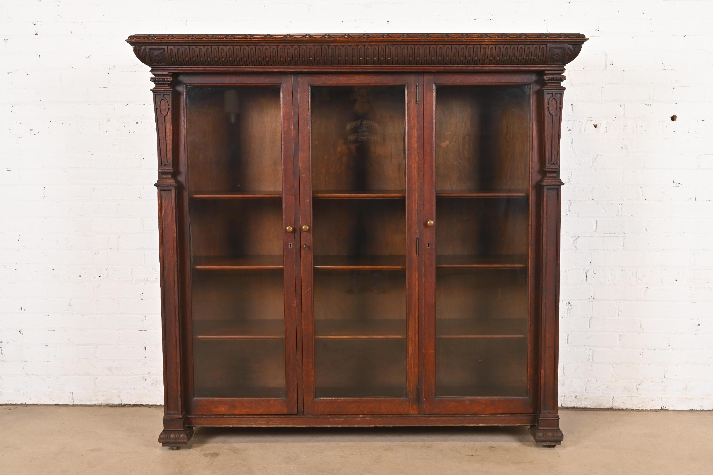 Magnifique meuble bibliothèque triple de style Empire américain ou de la fin de l'époque victorienne.

À la manière de J.R. Horner & Co.

États-Unis, vers 1890

Magnifique chêne sculpté, avec des portes vitrées et des ferrures en laiton d'origine.