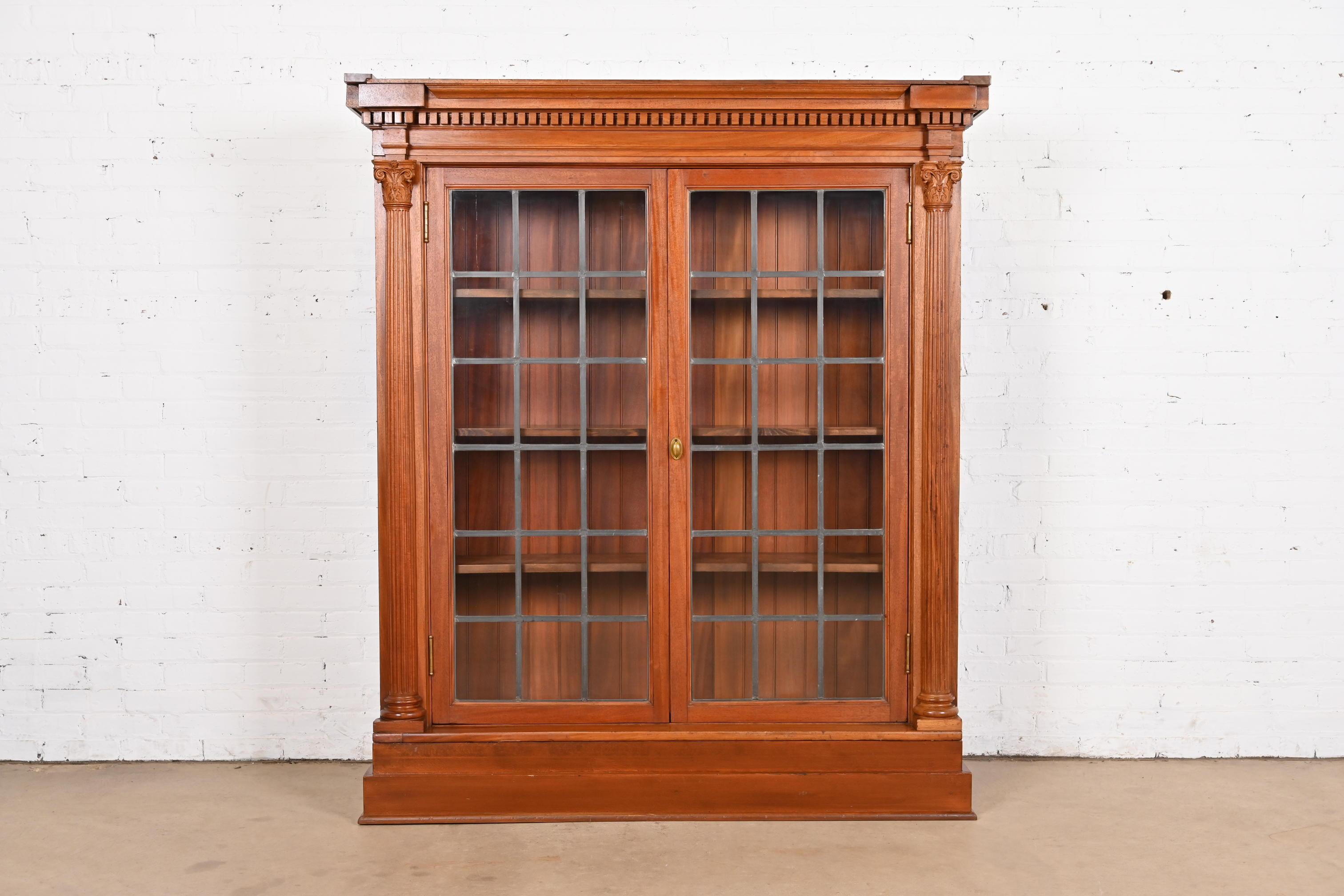 Magnifique meuble bibliothèque de style Empire américain, victorien ou néoclassique.

À la manière de J.R. Horner & Co.

États-Unis, vers 1890

Acajou sculpté, avec portes avant en verre plombé à meneaux, et quincaillerie en laiton
