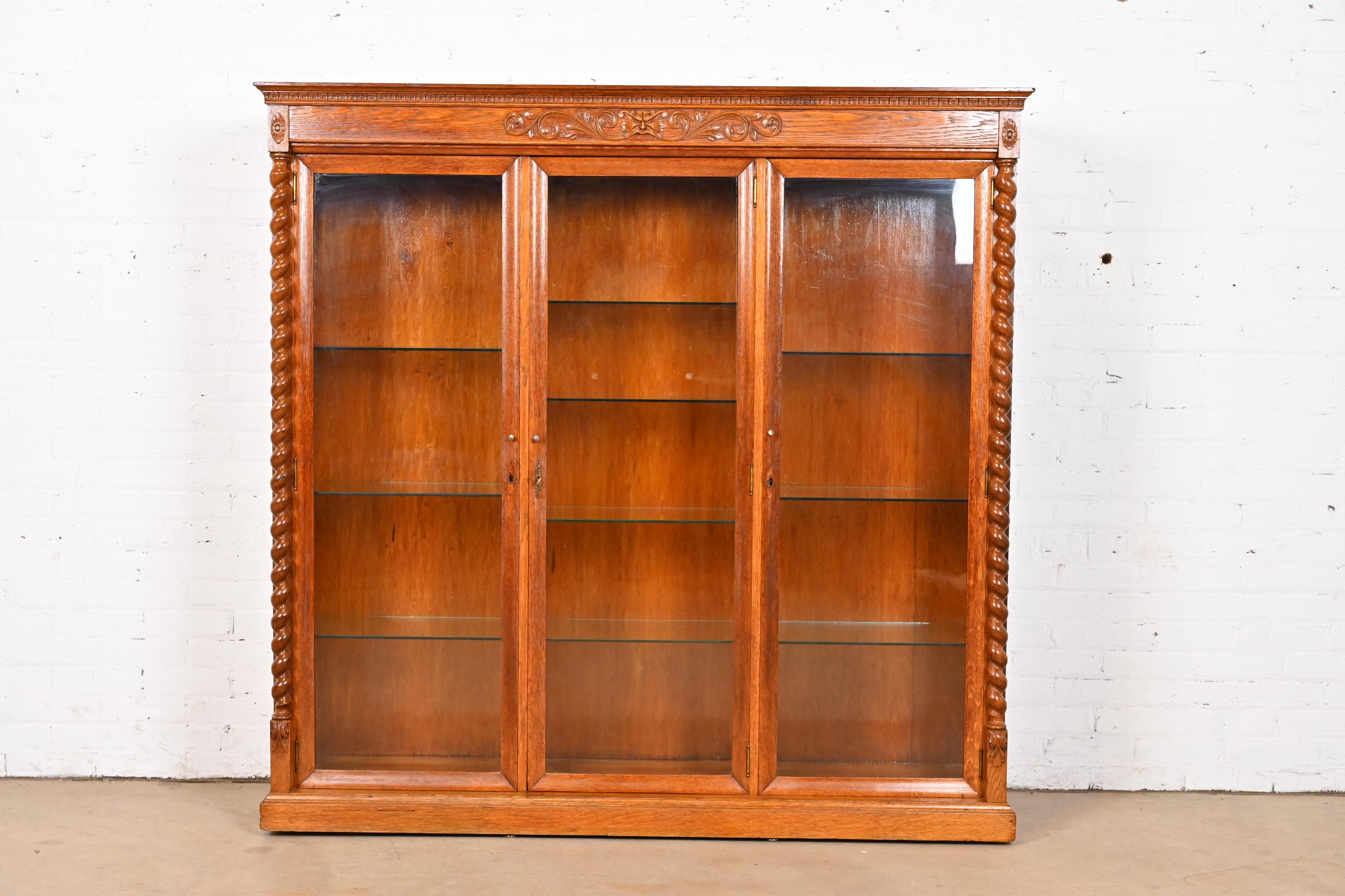 Magnifique bibliothèque ou vitrine triple éclairée de style victorien ou renaissance.

À l'instar de J.R. Horner & Co.

États-Unis, vers 1890

Chêne sculpté, portes vitrées et quincaillerie en laiton. L'armoire se verrouille et la clé est incluse.