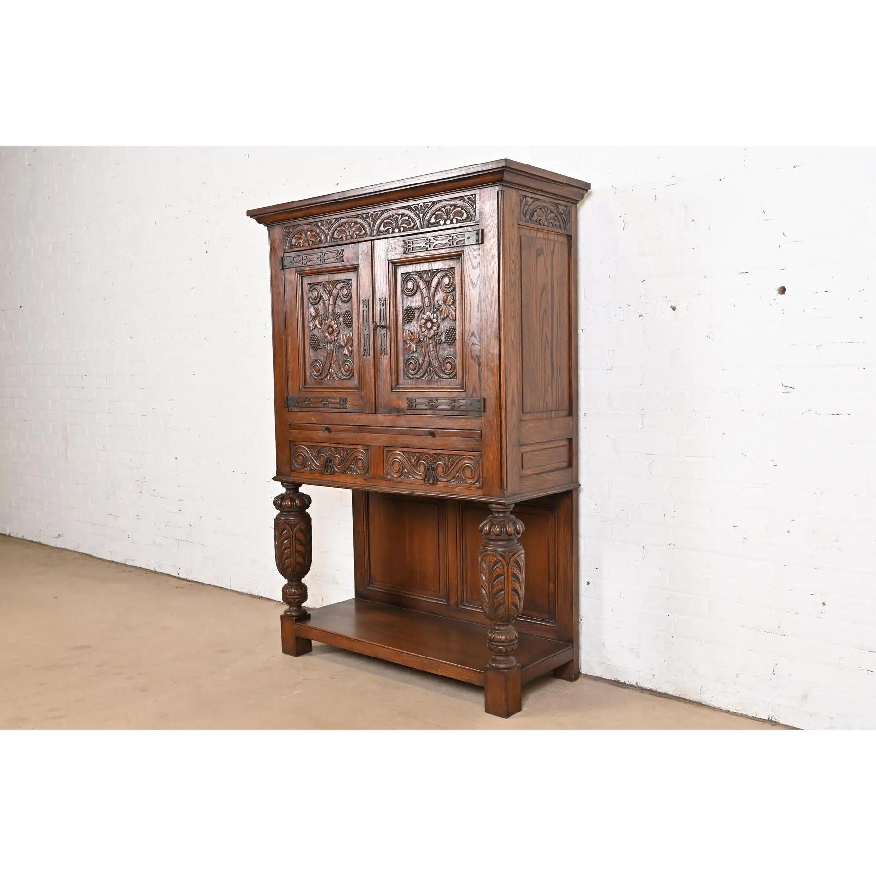 An exceptional English Jacobean, Victorian, or Renaissance Revival bar cabinet

In the manner of R.J. Horner & Co.

England, Circa 1900

Carved oak, with mirrored back interior, and original iron hardware. Cabinet locks, and key is
