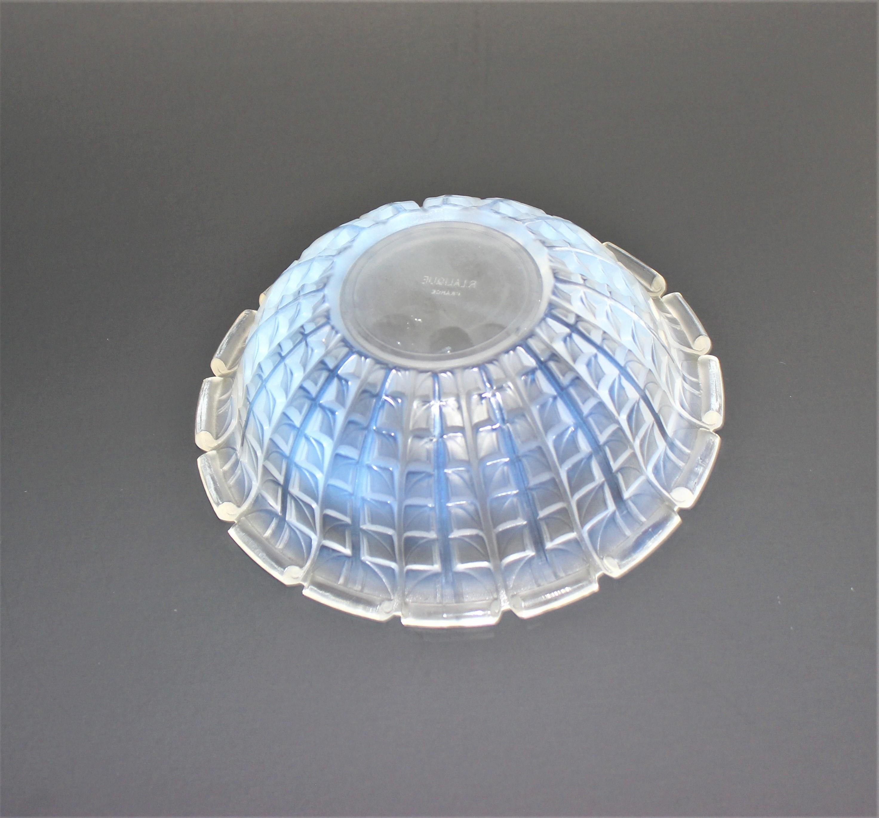 R. Lalique 1928 model acacia pattern opalescent crystal bowl from a Palm Beach estate.

This is a very subtle opaline coloring, in daylight against white it appears slightly yellow tinged with a fleeting whisper of light blue, but on a black
