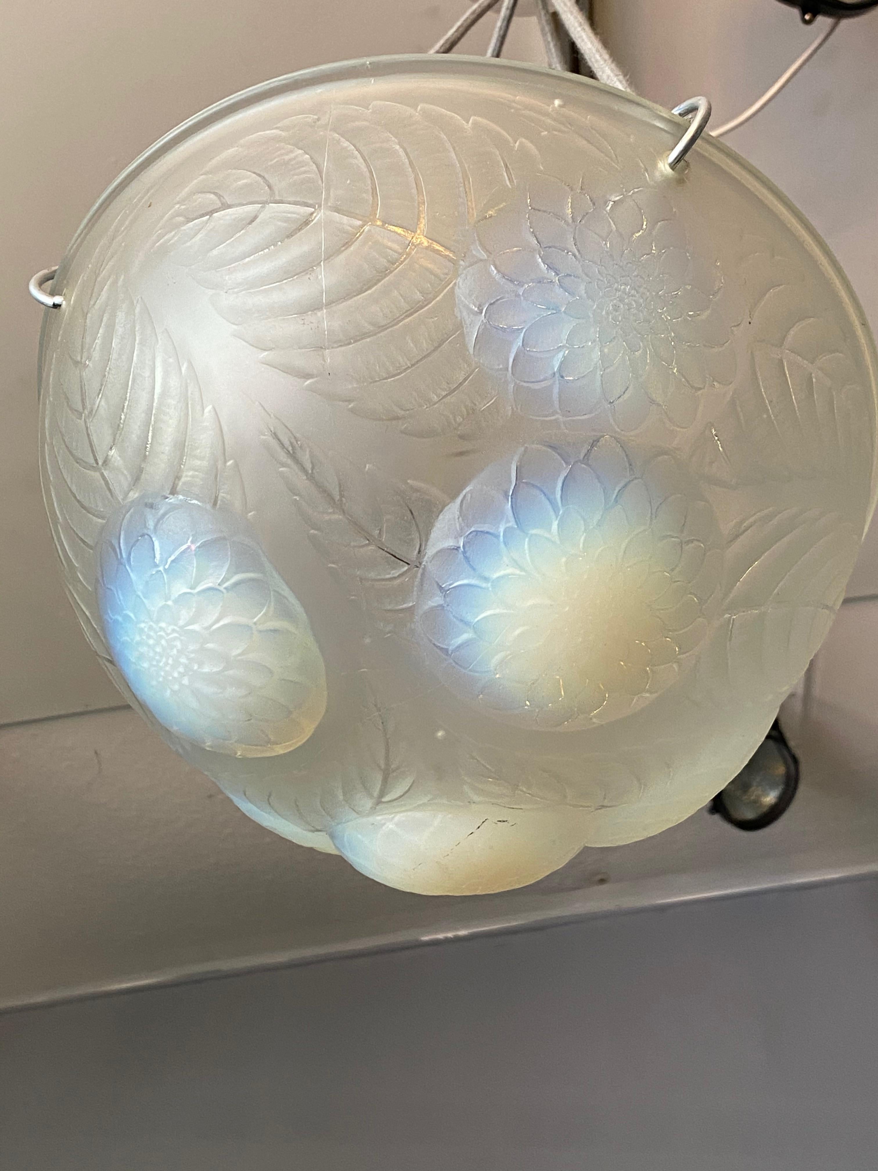 Opalescent Chandelier dahlias,
model created in 1921
 Modèle crée en 1921. , . Signé R. Lalique H: 65 cm Diam: 30 cm 
a hanging lamp with a bowl in opalescent moulded-pressed, opalescent glass supported by grey ropes. Signed «R.Lalique». Model