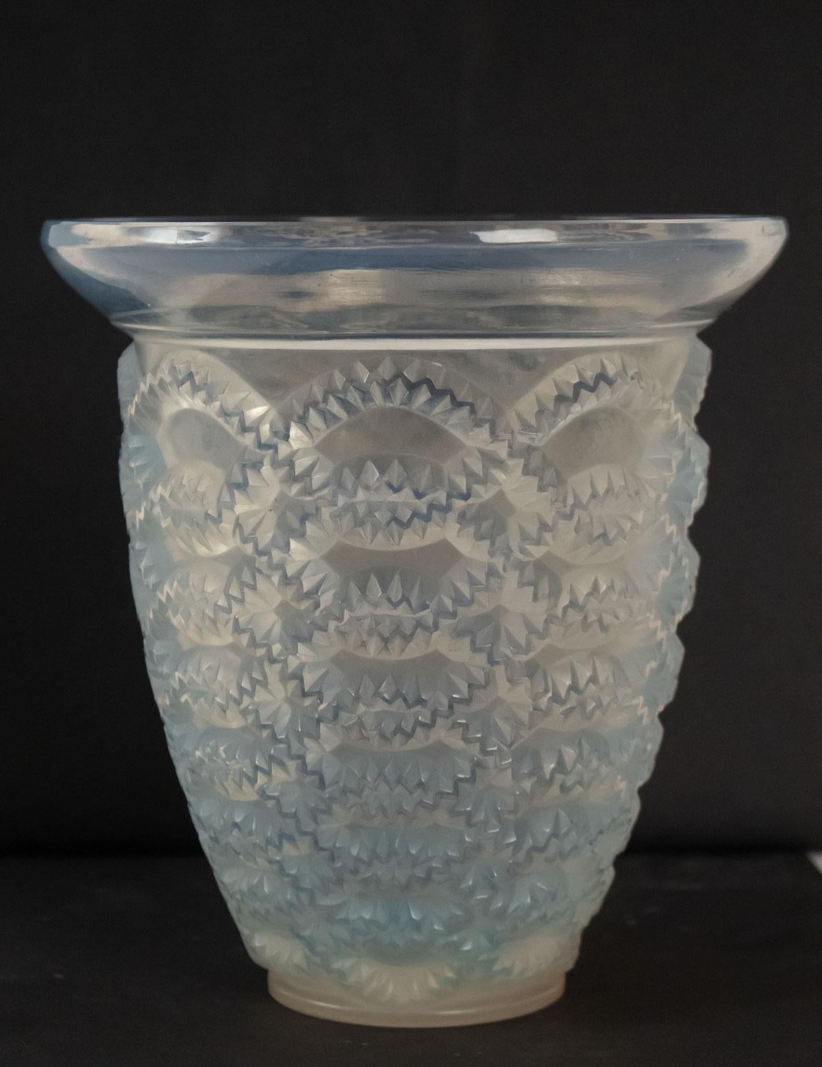 Pressed molded opalescent glass 21 cm tall
Model created in 1935
Bibliography: Marcilhac Model: 10-887
Ress molded garlands decorated body under a widening undecorated top rim.
 