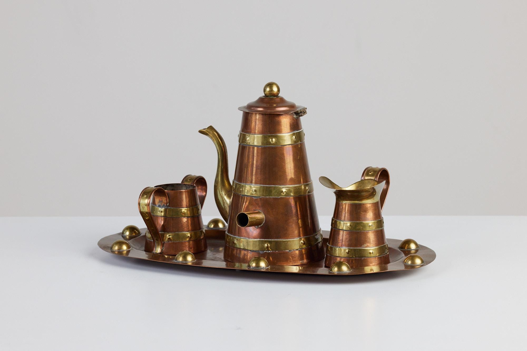 A four piece mid-century brass tea service set by R. Martinez, c.1950s Mexico. The set includes a lidded copper teapot with creamer and sugar pot both with curved handles. All the pieces feature circular textured brass ribbing around the vessels.