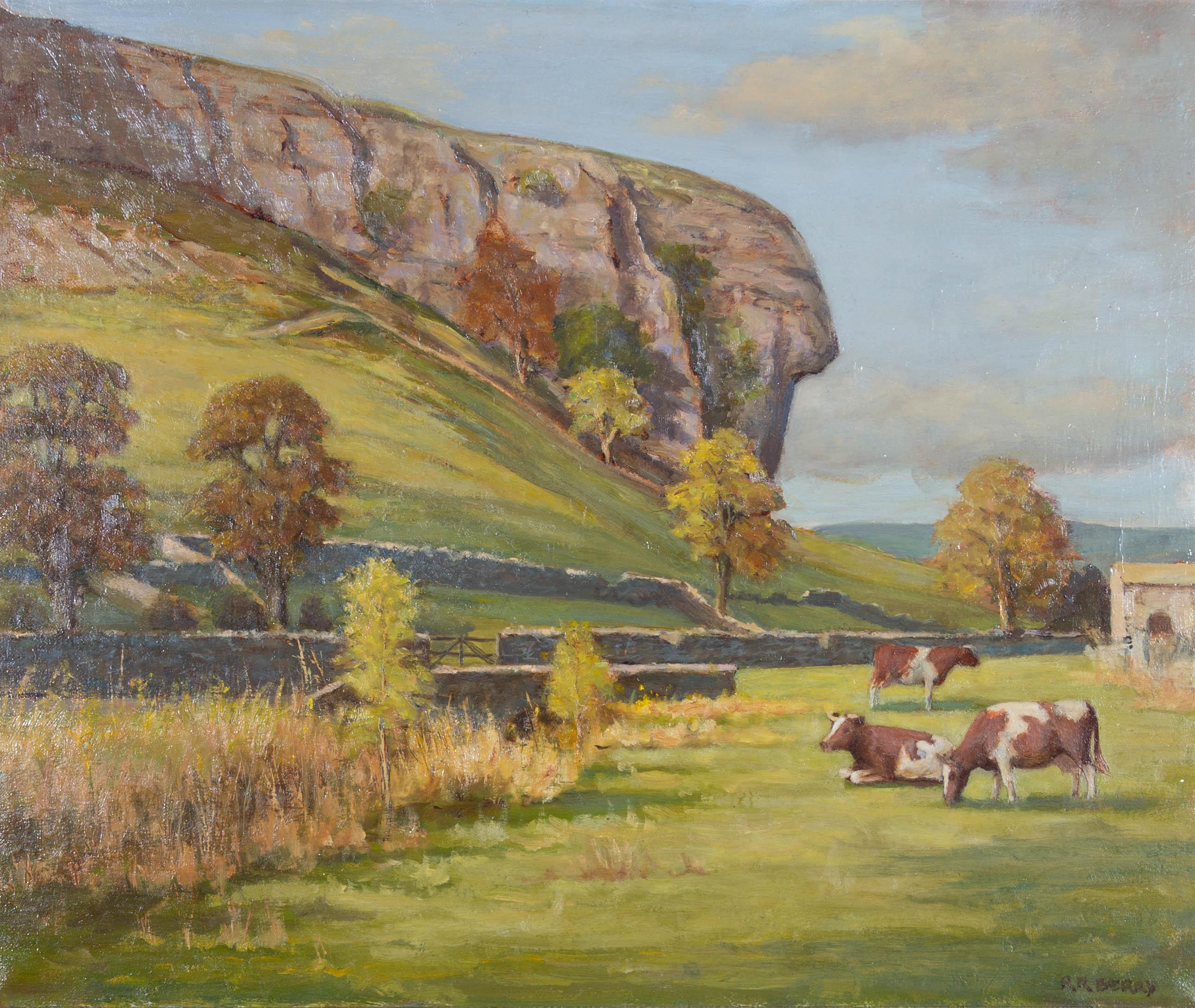 An attractive 20th Century pastoral landscape showing cattle grazing in the fields at the foot of the impressive Kilnsey Crag in Yorkshire. The artist has signed to the lower right and the painting has been presented in an off white frame with gold