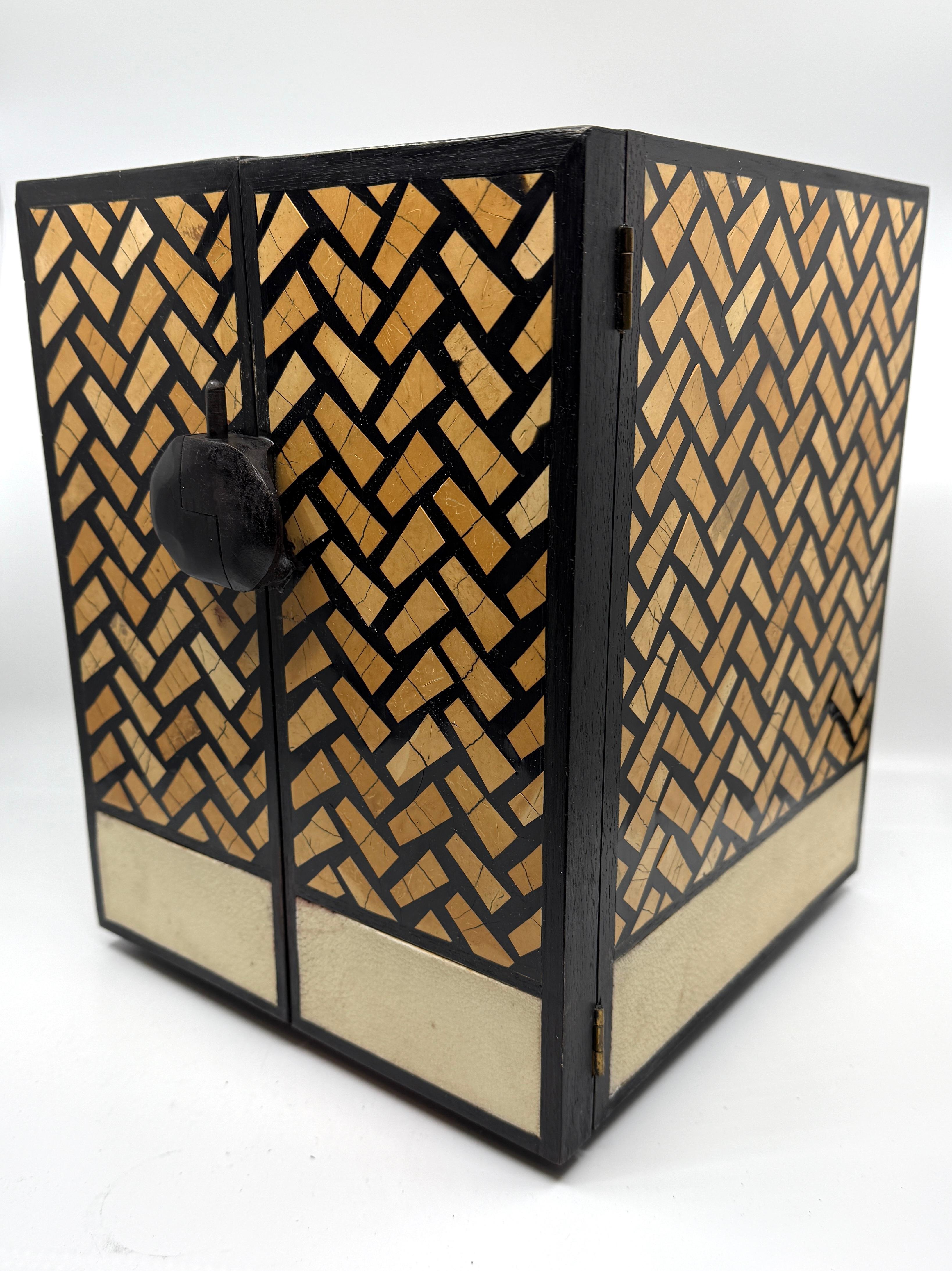 Ravissante boîte à bijoux en bois marqueté et galuchat, réalisée par le célèbre cabinet de design R&Y Augousti. Cette jolie pièce artisanale est fabriquée aux Philippines. Il présente une bordure en galuchat sur le fond et des façades de tiroirs