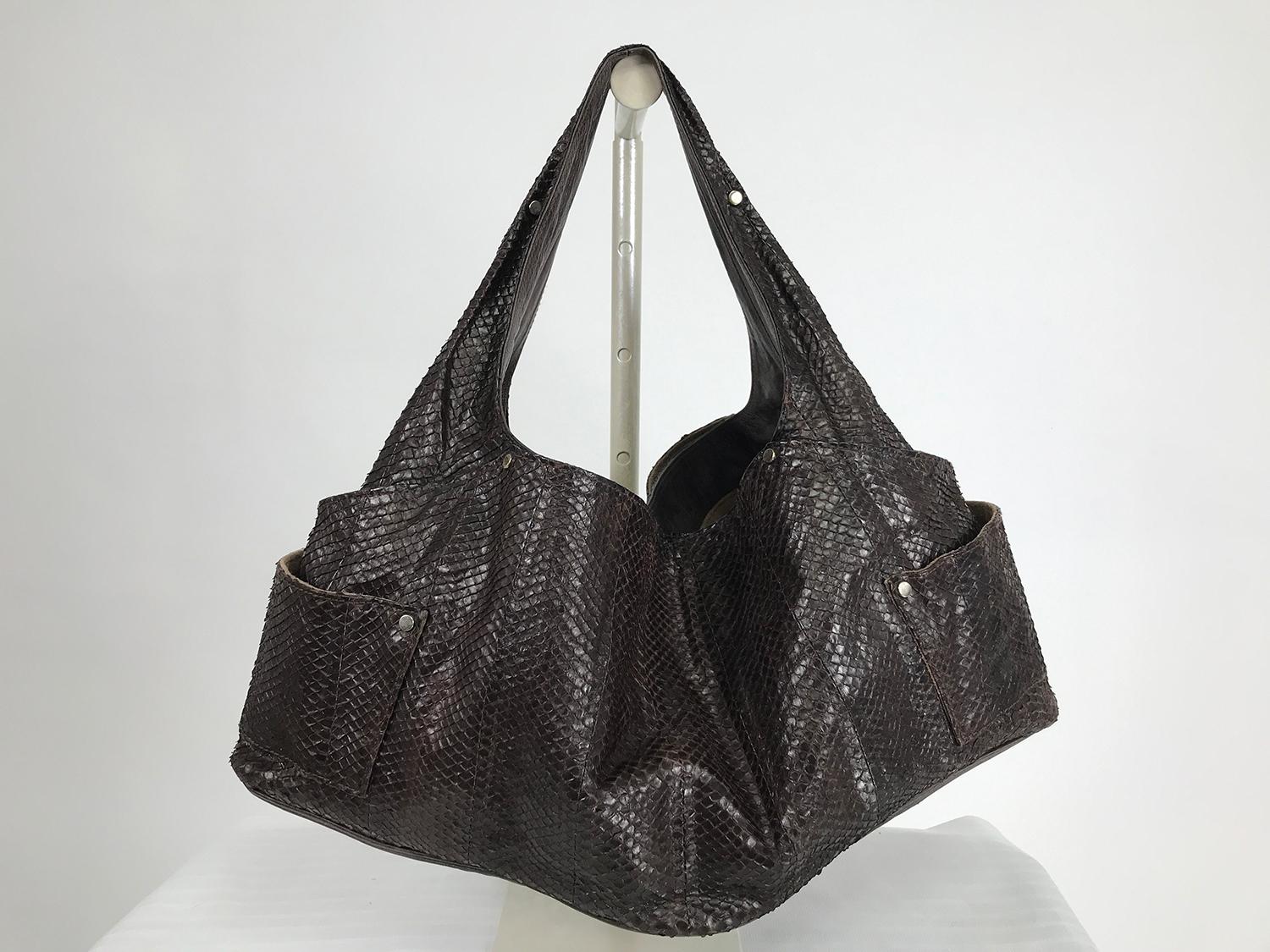 R & Y Augousti Paris large brown snakeskin shoulder bag with silver studs. Soft skin bag has a leather lined shoulder strap that is incorporated in the bags design. The bag is large with outside slip compartments on either long side, there are