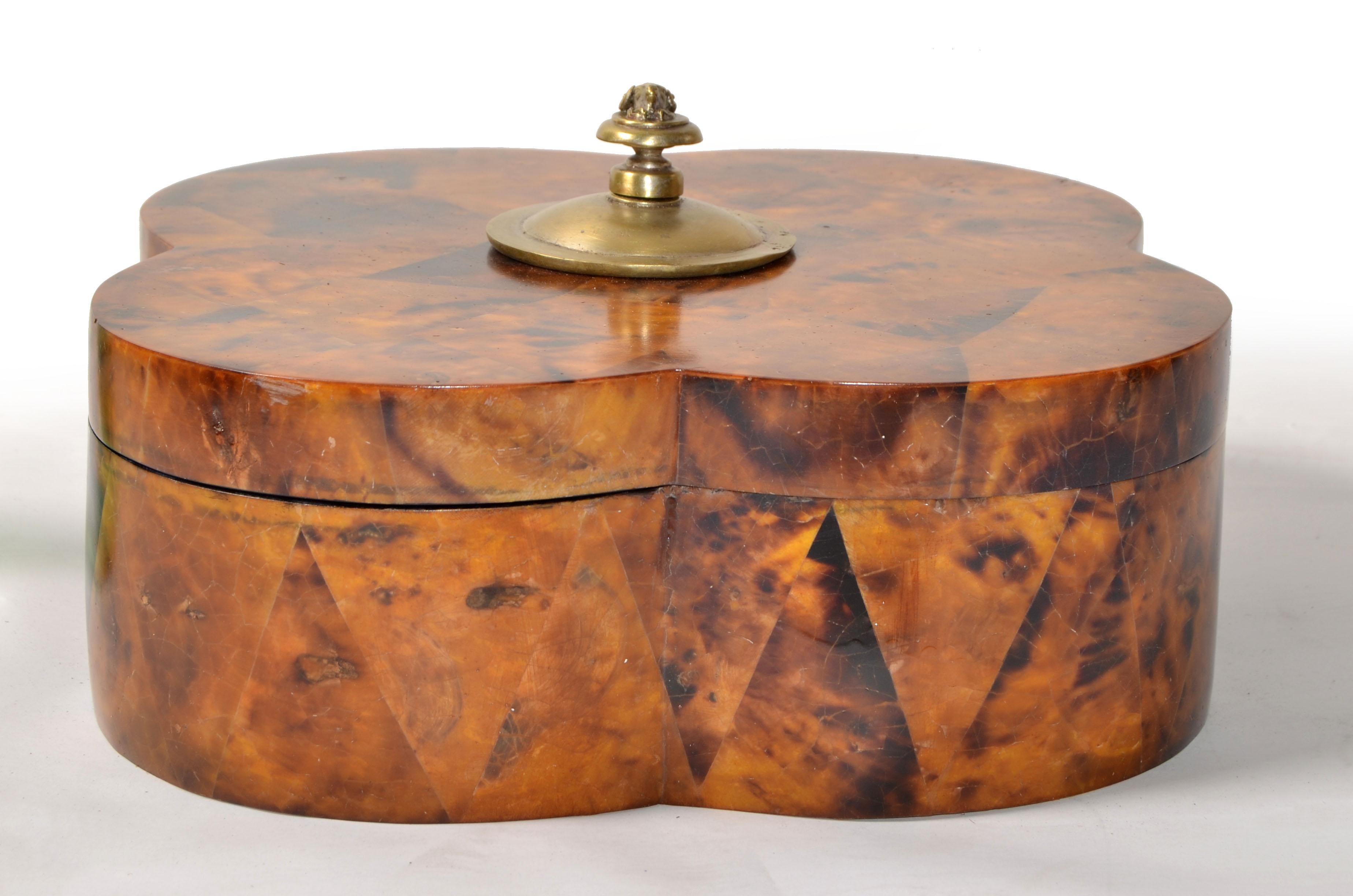 Graziosa scatola per gioielli, orologi o oggetti decorativi attribuita a R & Y Augousti in legno di latifoglie di tabacco con intarsi in velluto nero.
A forma di trifoglio con pomello di stambecco in bronzo in stile Biedermeier. 
Ottimo Treasure