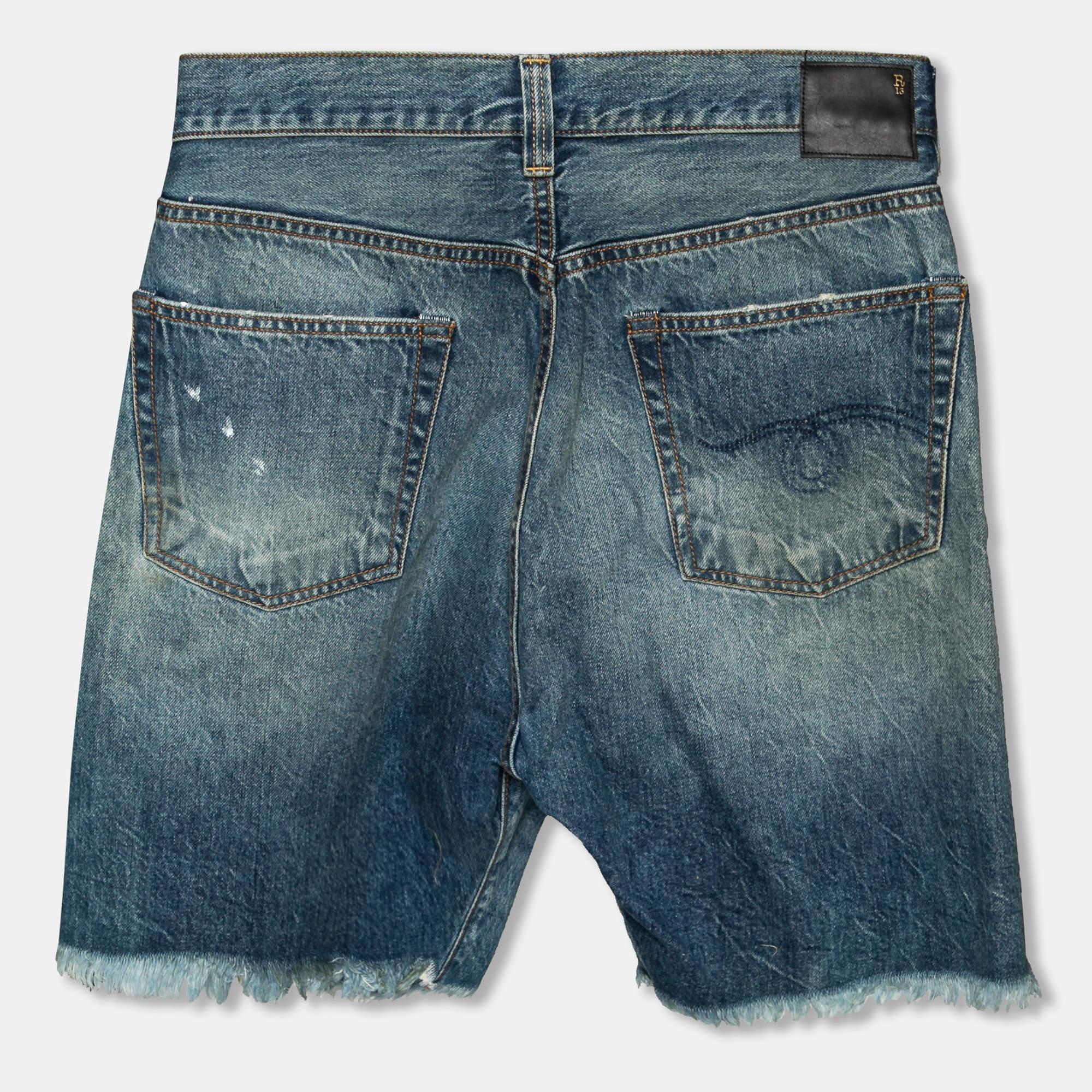 Aktualisieren Sie Ihre Garderobe mit diesen Shorts von R13. Diese blauen Denim-Shorts mit asymmetrischem Frontverschluss, fünf Taschen und ausgefransten Rändern sorgen für eine bequeme Passform und einen modischen Look. Tragen Sie sie mit einem