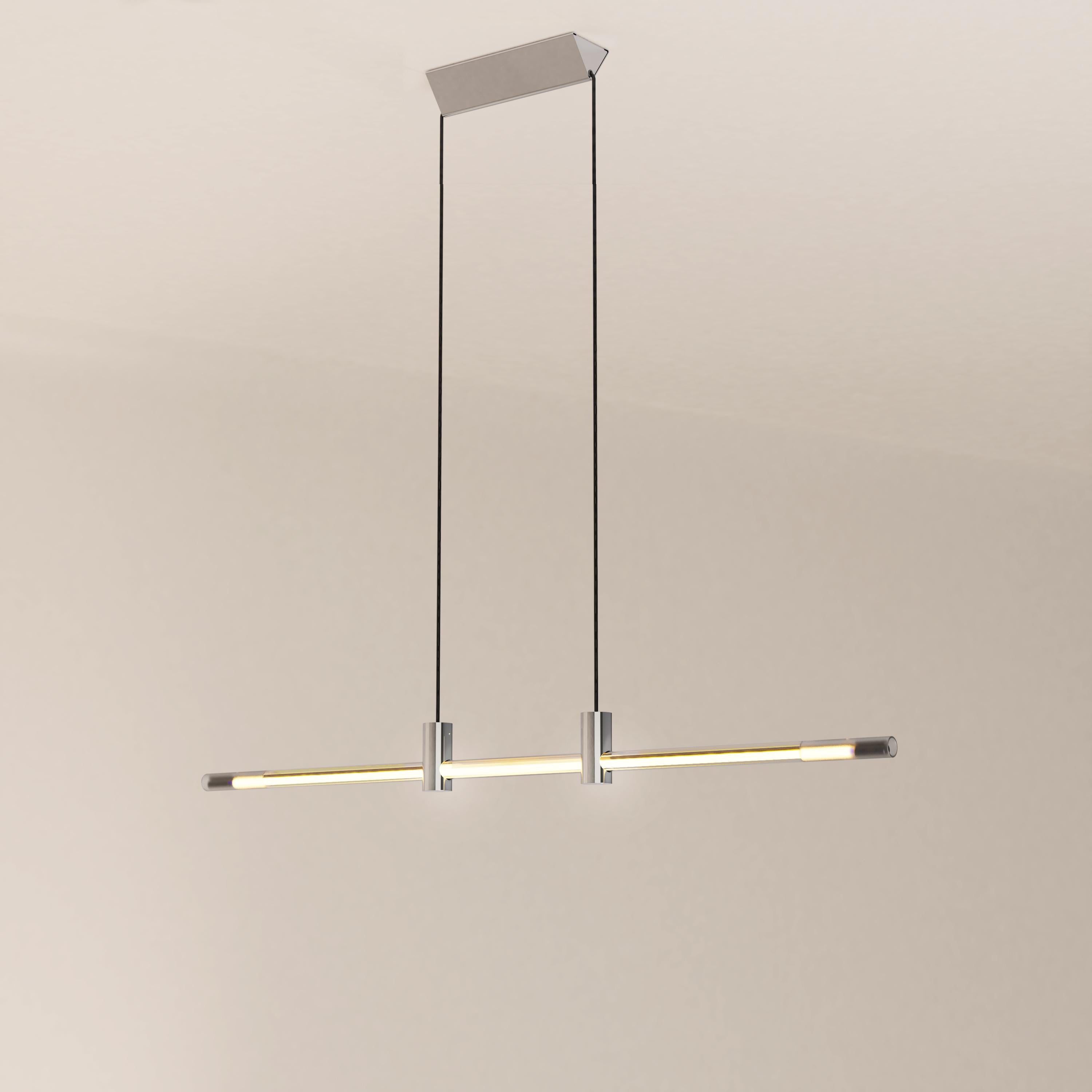 The Ra Line in its chrome plated finish is a contemporary hand-blown glass and brass pendant lighting.

The Ra Line is distinguished by a marked opposition between heaviness and lightness. The assemblage of the borosilicate glass tube