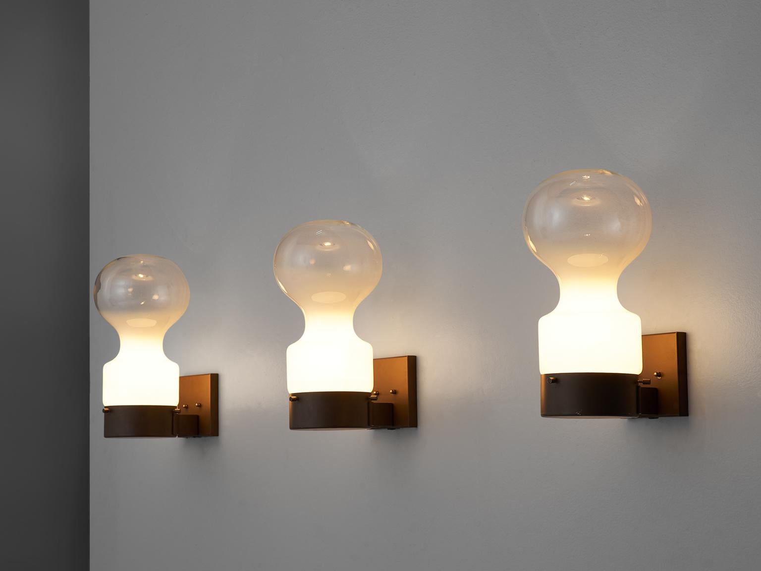 RAAK Amsterdam, dew drop wall lights, glass, iron, The Netherlands, 1960s.

This set of three wall lights is designed by RAAK Amsterdam. The frame is made of brown iron and the bulbs are made of glass. The bottom half of the shade is opaque and the