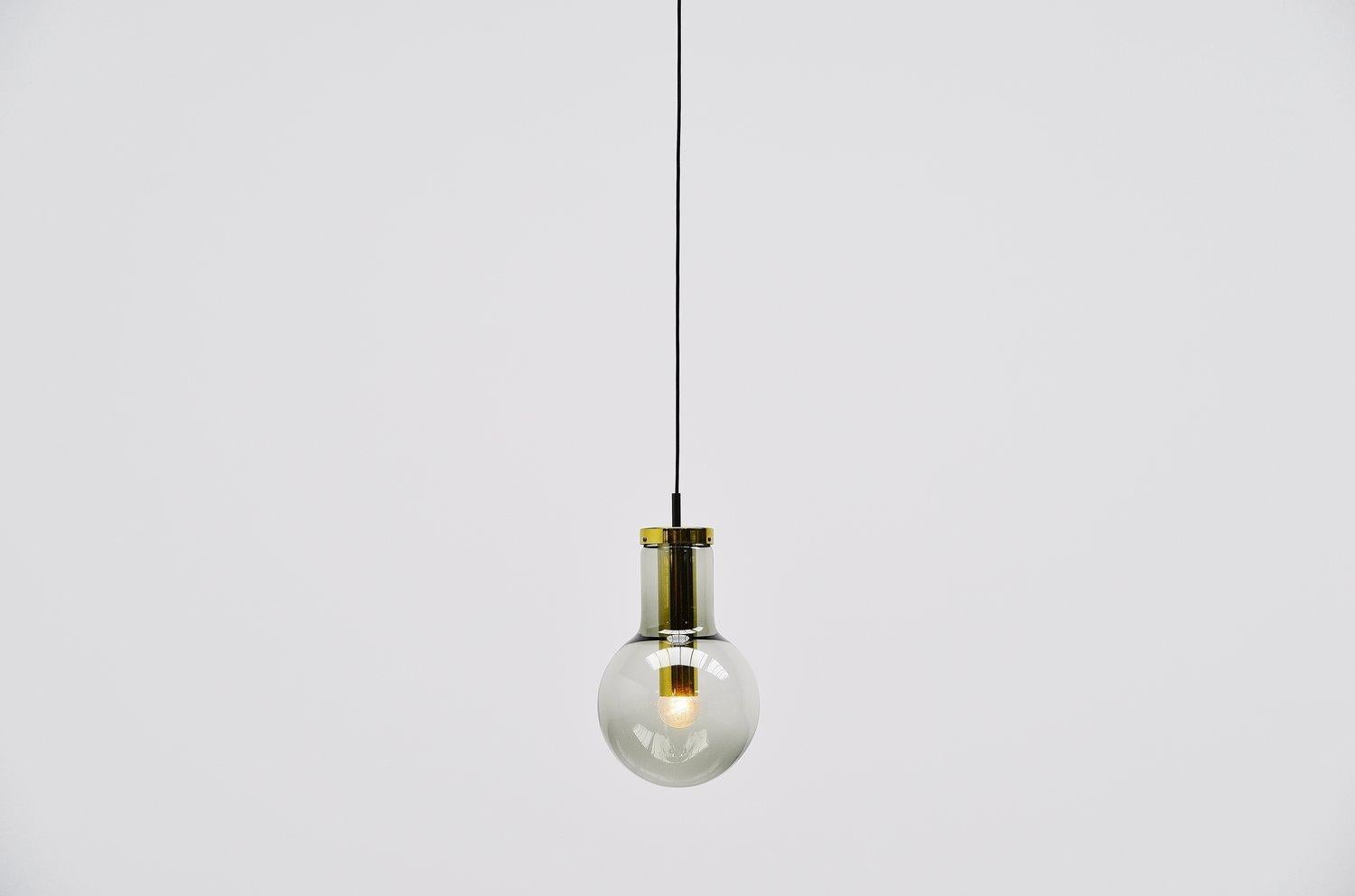 Very nice pendant lamps model Maxi Globe designed and made by Raak Amsterdam, The Netherlands 1965. These pendants have a brass base carrying a smoked glass shade. This beautiful lamp can be used as ceiling or as hanging lamp. Very nice to use in a