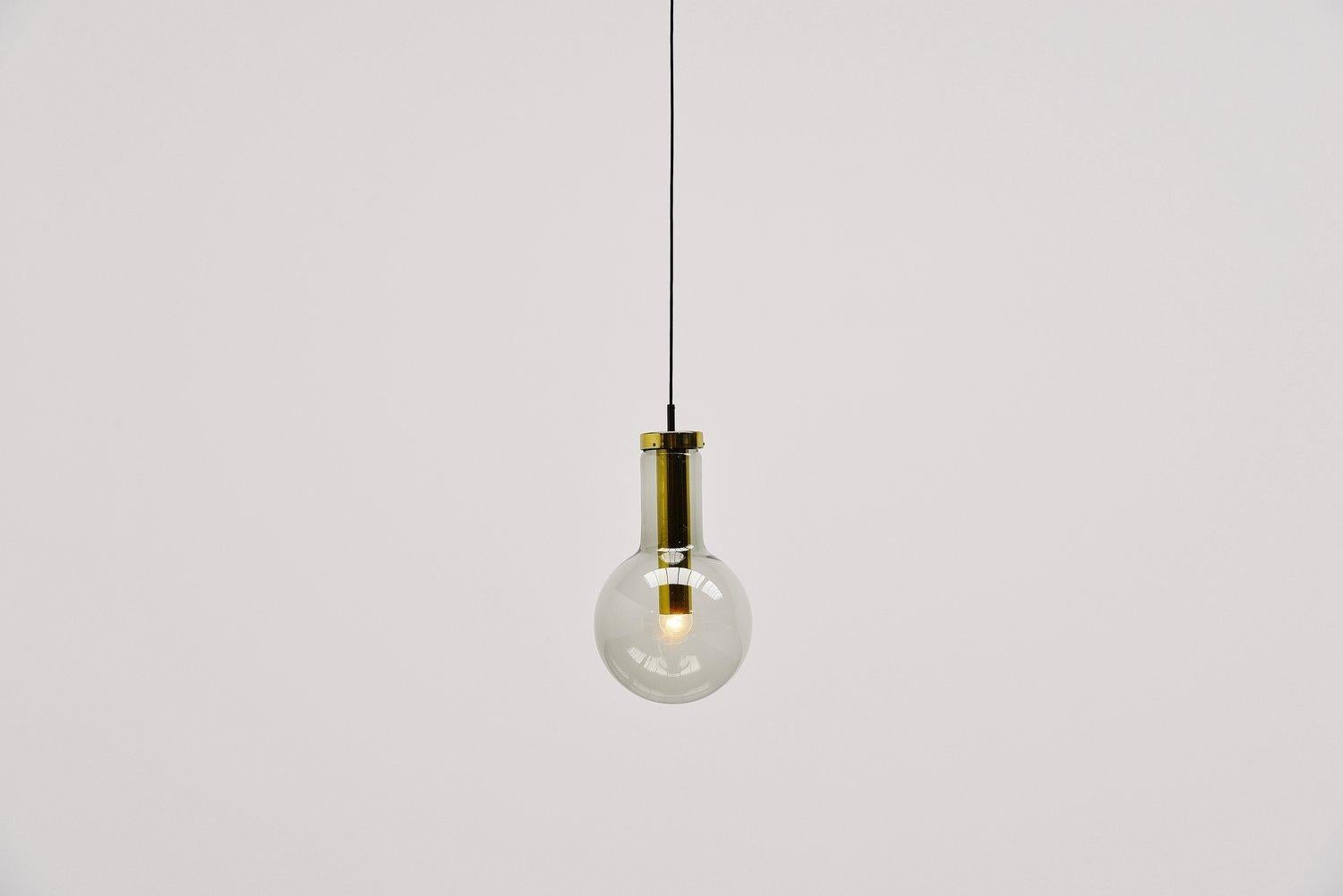 Very nice pendant lamps model Maxi Globe designed and made by Raak Amsterdam, The Netherlands 1965. These pendants have a brass base carrying a smoked glass shade. This beautiful lamp can be used as ceiling or as hanging lamp. Very nice to use in a