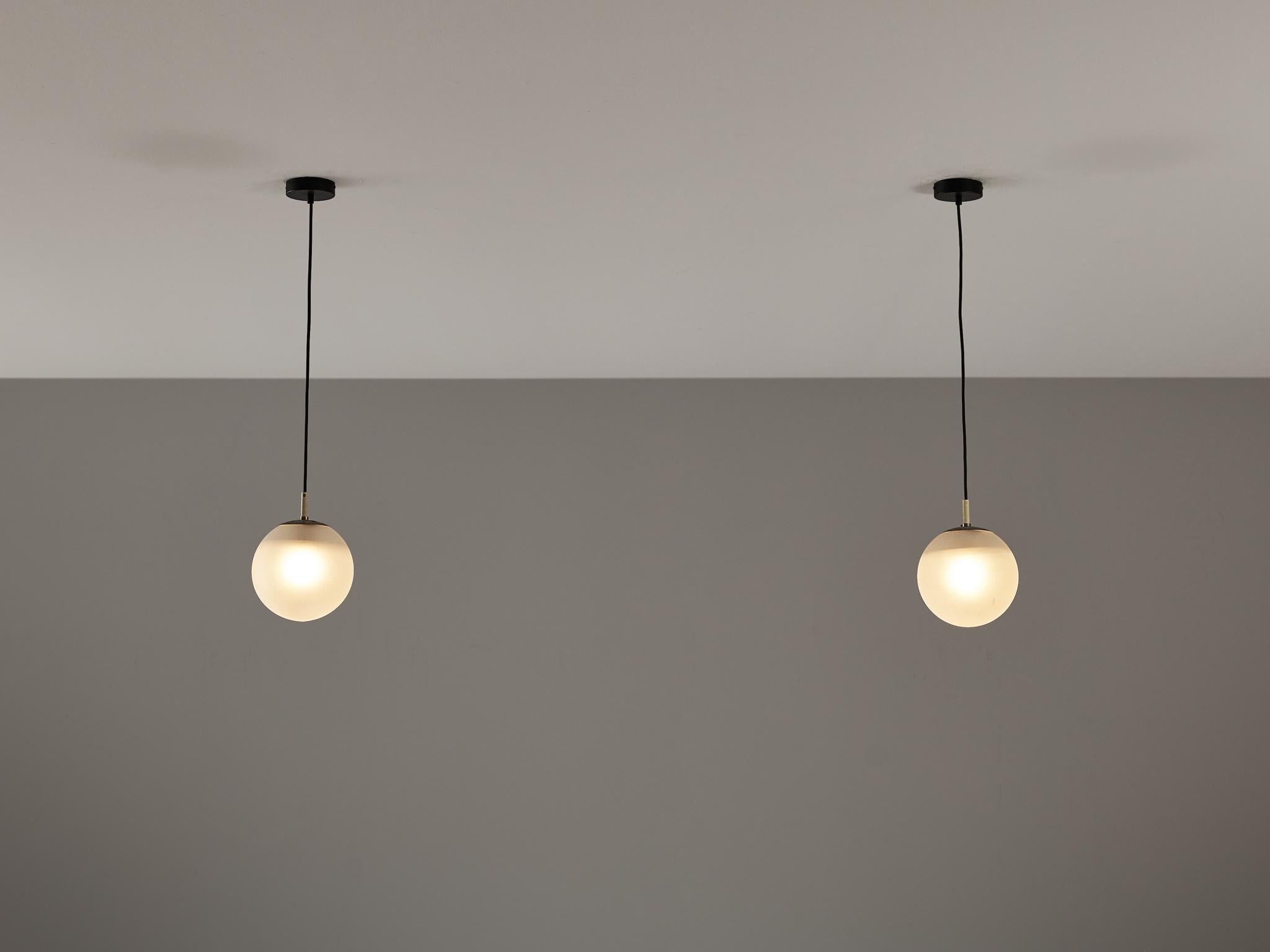 RAAK Amsterdam, pendants, satin glass, metal, Europe, 1970s.

This atmospheric set of pendant lamps features each a frosted glass orb, casting a gentle and soothing light tone that imbues the space with a vibrant atmosphere. The lamps can be hung