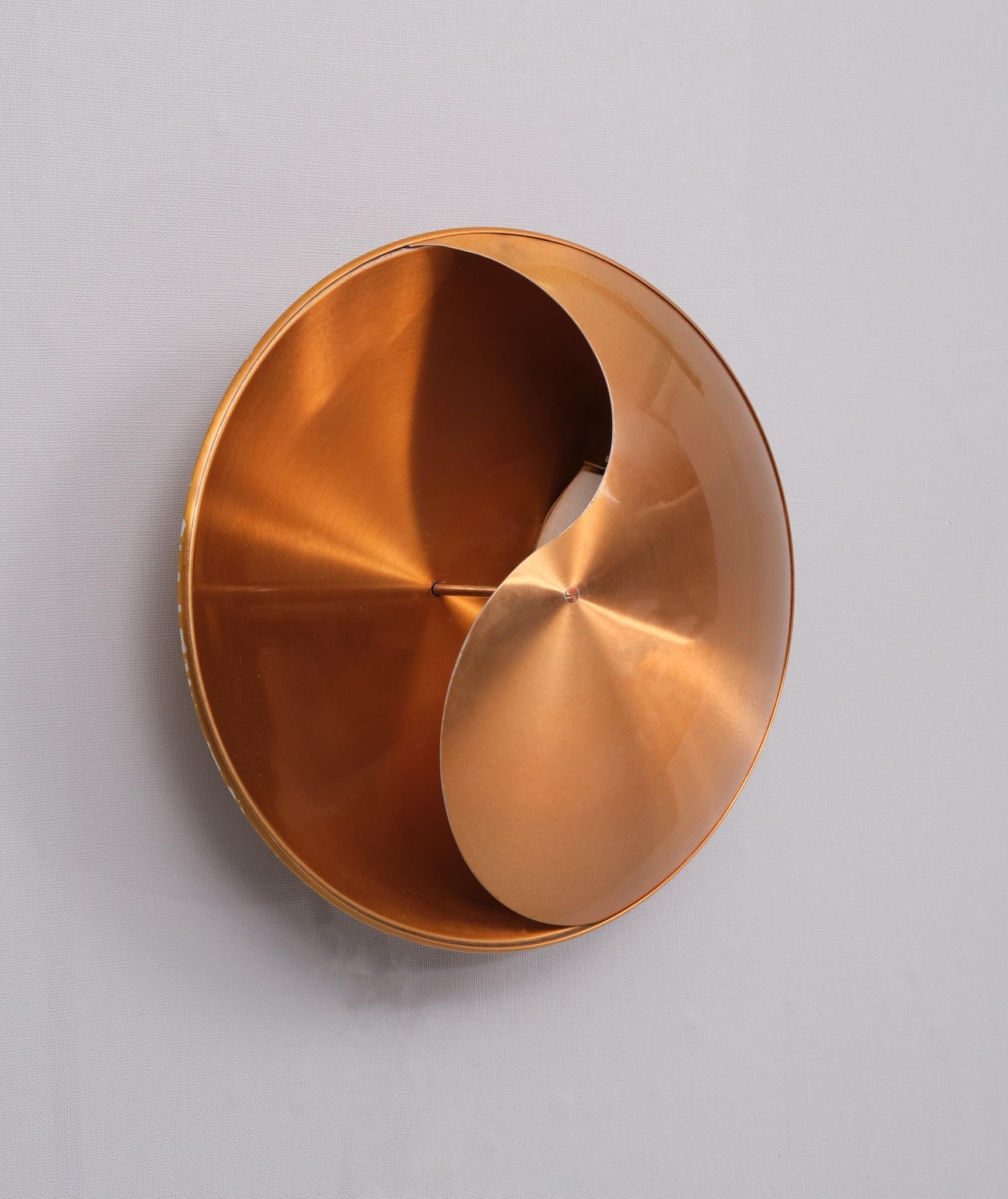 Copper-colored Aluminum Yin Yang wall lamp .designed by Hermian Sneyders de Vogel for Raak in about 1968. Hermian Sneyders was a designer and goldsmith. She discovered in herself a passion for luminous jewelry, balance between light and dark and a