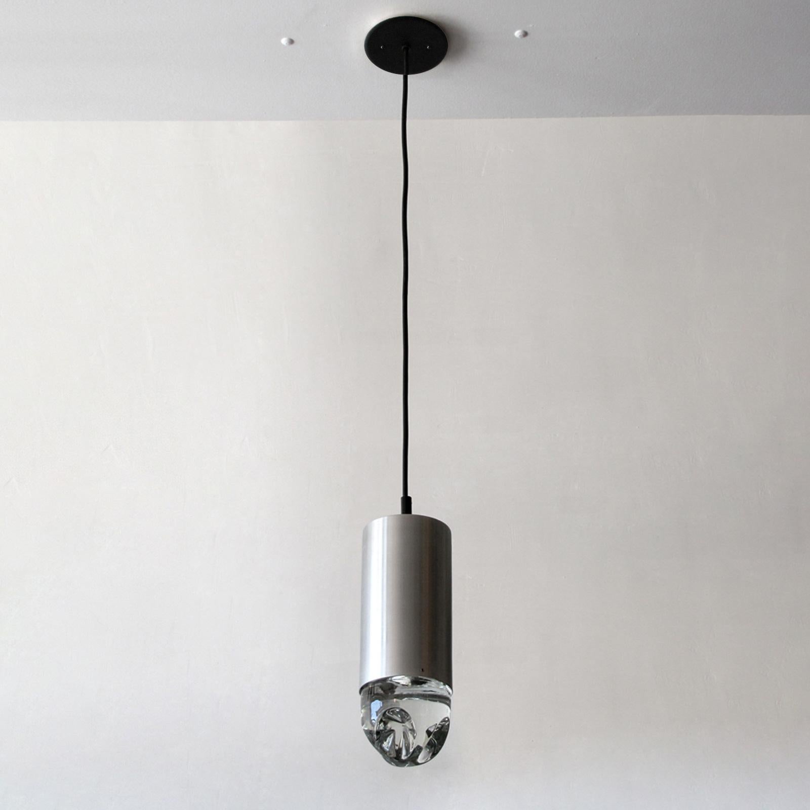 Stunning pendant lights with solid glass bodies suspended from an aluminum cylinder by RAAK, Holland, total drop is fully adjustable on request. Priced individually.
