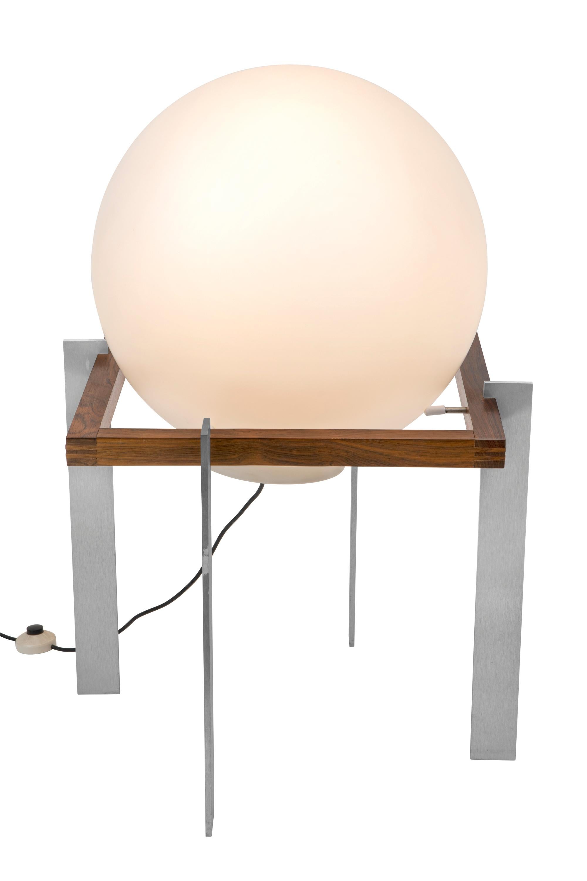 Founded in 1954 by Carel O. Lockhorn, Raak is recognized as one of the most important Dutch lighting manufacturers of the 20th century. The lamp has a solid rosewood square frame with solid aluminum legs and a large matte white glass ball. The