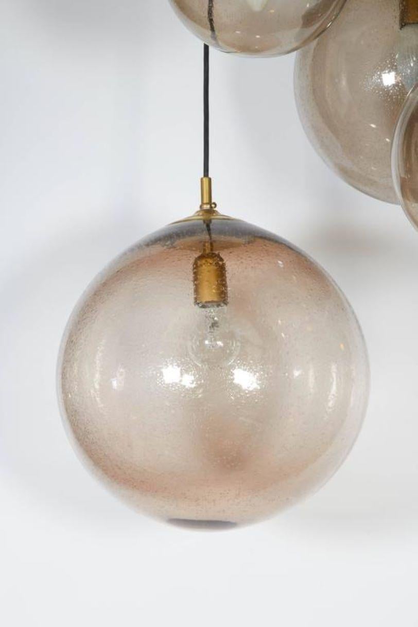 Lampe suspendue de style moderne hollandais RAAK, fabriquée en 1965, avec quatre pendentifs globe en quinconce, abat-jour en verre fumé à bulles d'air. 52