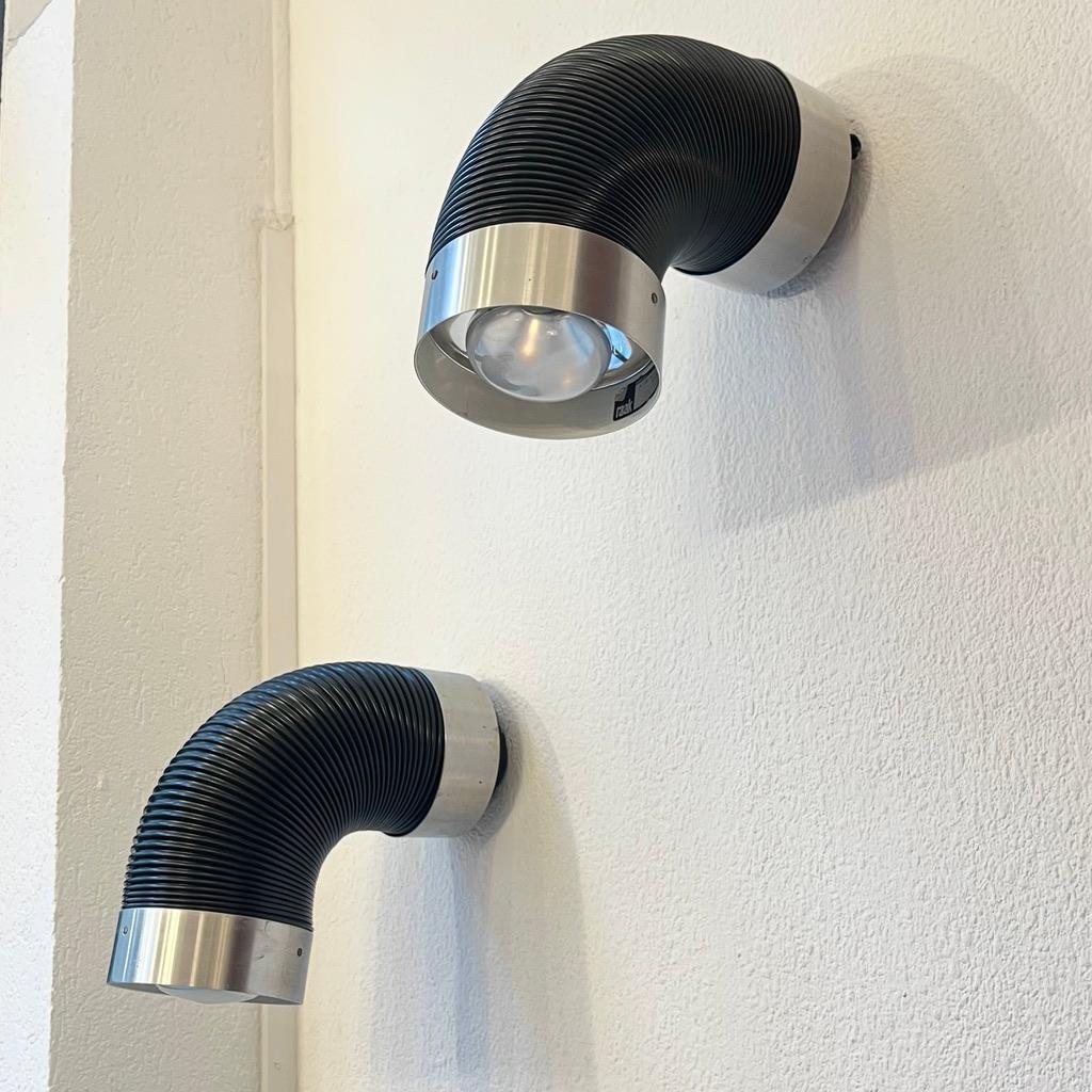 Paar Wandlampen, hergestellt von RAAK Netherland. Gummi und gebürstetes Aluminium. Gelenkig, einstellbar.
Kann sowohl als Wand- als auch als Deckenleuchte verwendet werden.
RAAK ist  eine niederländische Beleuchtungsmanufaktur von guter Qualität,