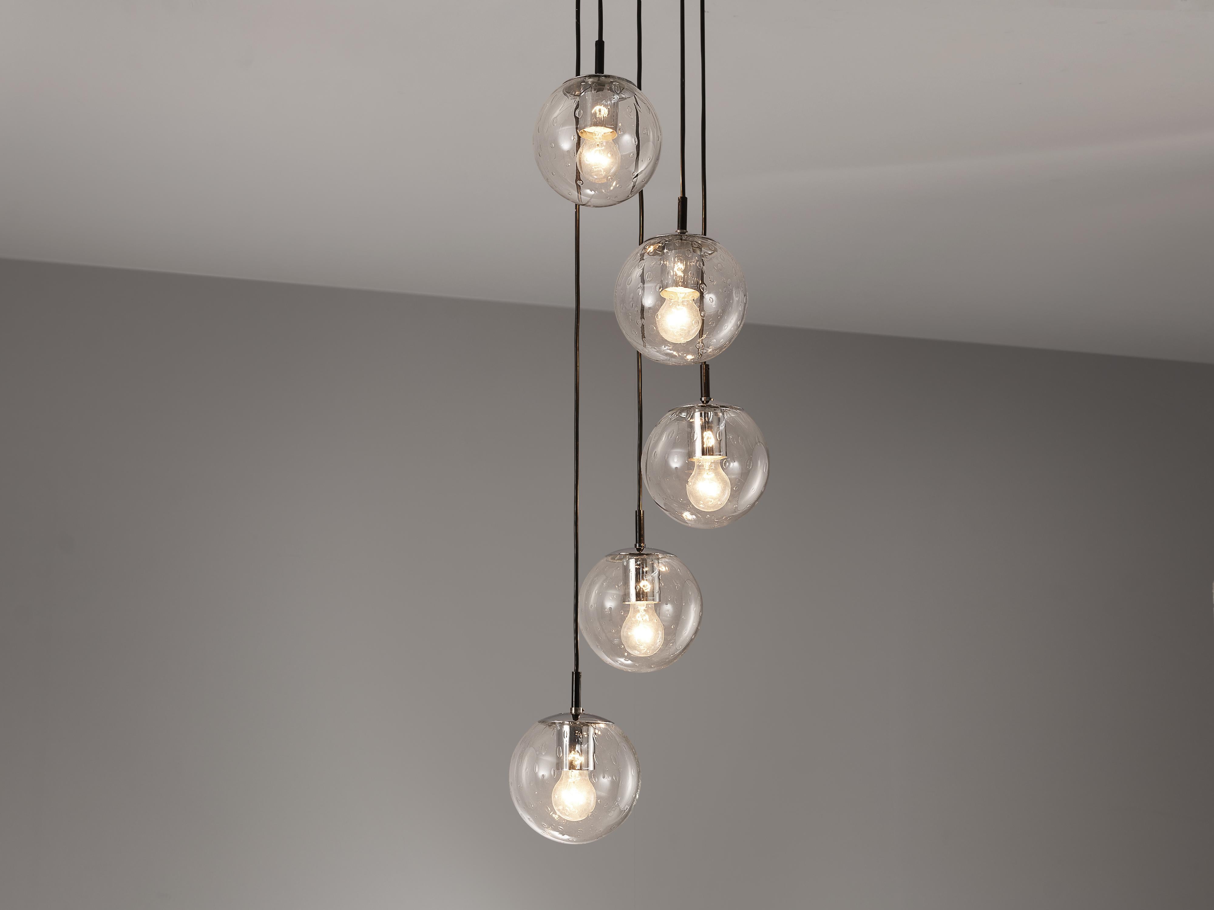 RAAK Amsterdam, pendant with five 'Bubble' spheres, glass, chrome-plated metal, The Netherlands, 1960s 

A sophisticated composition of five hand-blown glass pendants is created by the Dutch manufacturer RAAK Amsterdam. As a result of the hand-blown