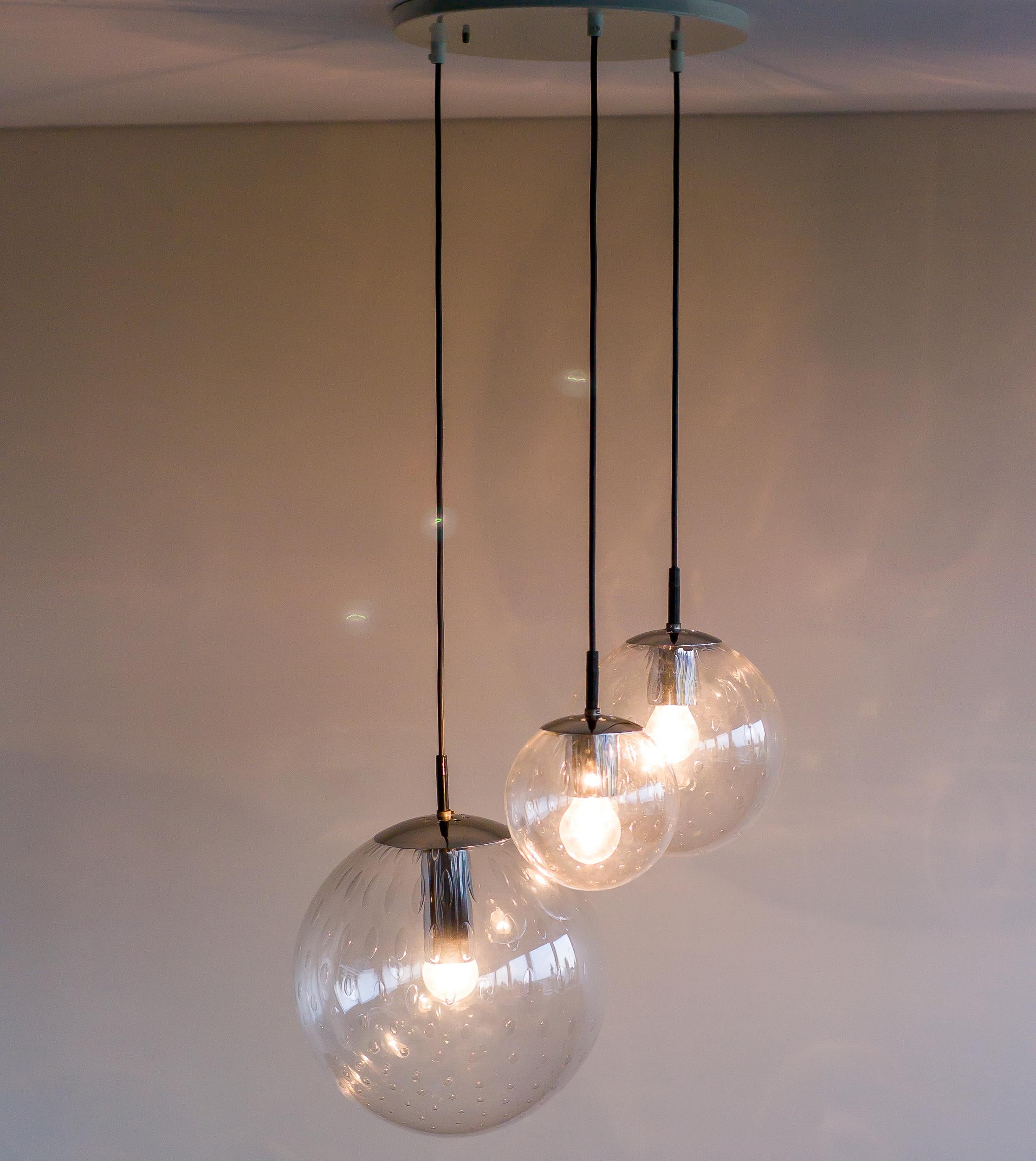 Splendido lampadario di RAAK con sfere di vetro trasparente soffiato a mano con bolle racchiuse.
I diametri delle sfere di vetro sono 30 cm, 22 cm e 14 cm.
L'altezza di ogni sfera può essere regolata per creare una composizione personalizzata.
I tre